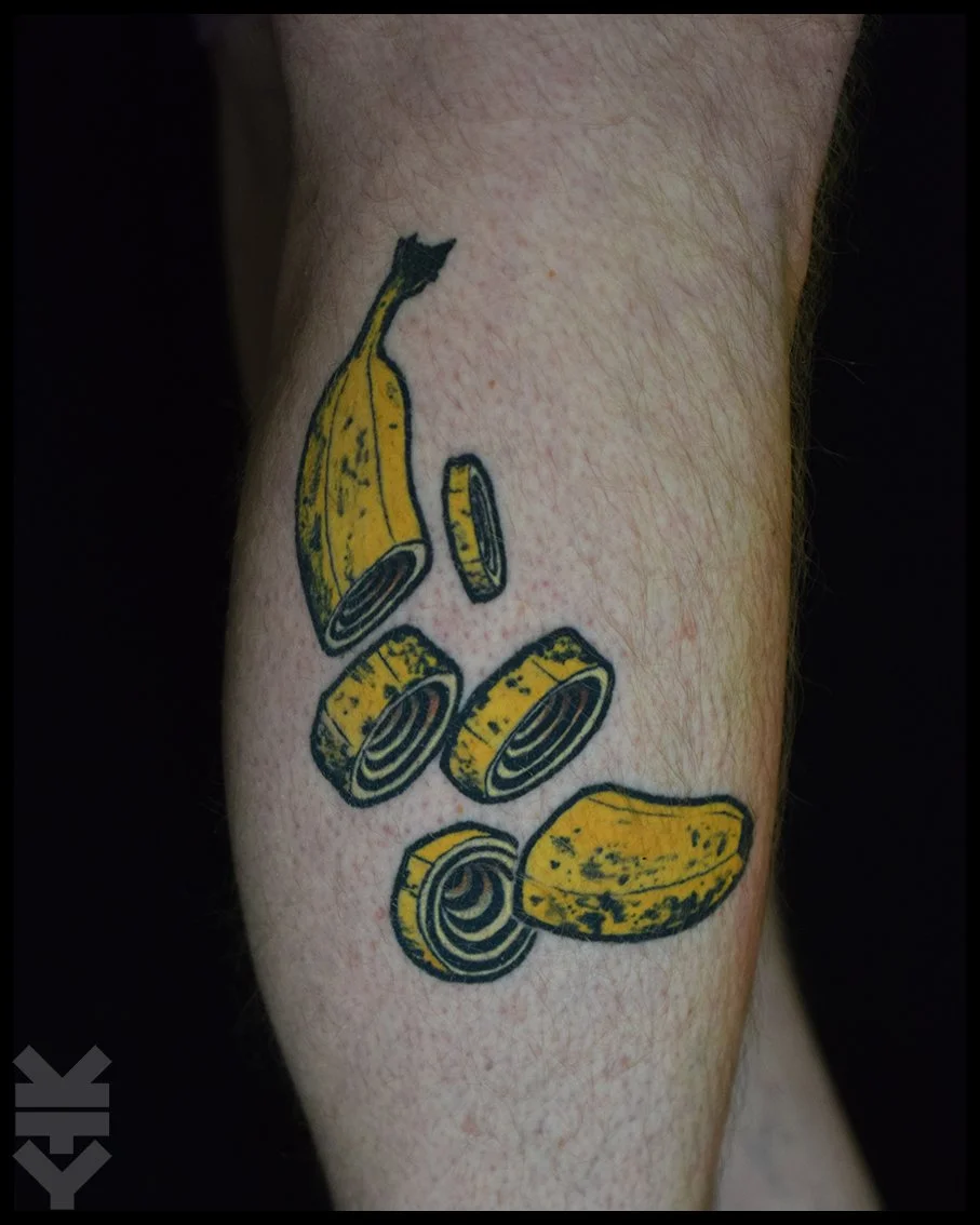 Tattoo of a sliced banana on a person's arm.