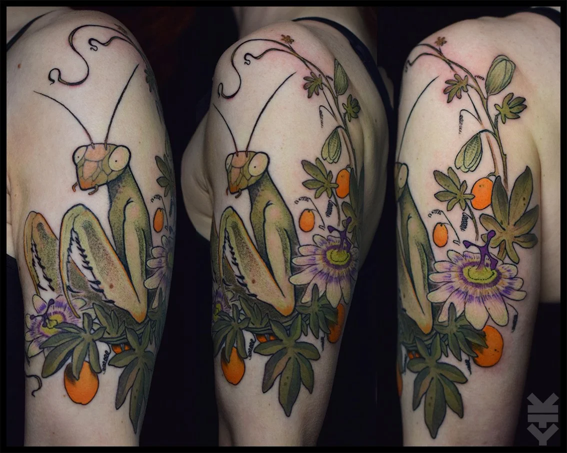 Tattoo of a praying mantis surrounded by flowers and foliage on a person's shoulder.