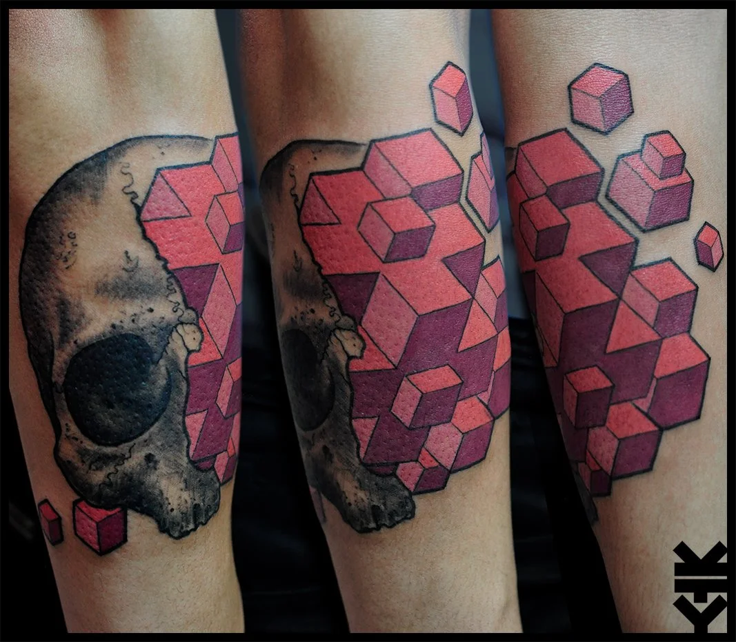 Tattoo of a realistic human skull with geometric cubes in shades of pink and red emerging from it.
