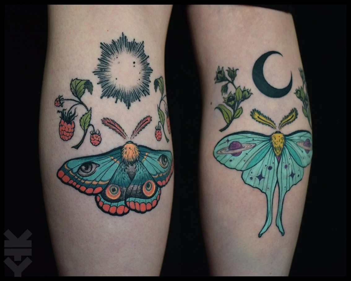 Two tattoos on person's thighs, one featuring a moth and a sky with a black sun and stars, and the other featuring a butterfly and a night sky with a crescent moon and flowers.