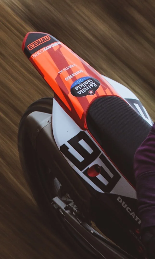 Vista de una motocicleta Ducati en movimiento, con un neumático en acción y un fondo borroso por la velocidad.