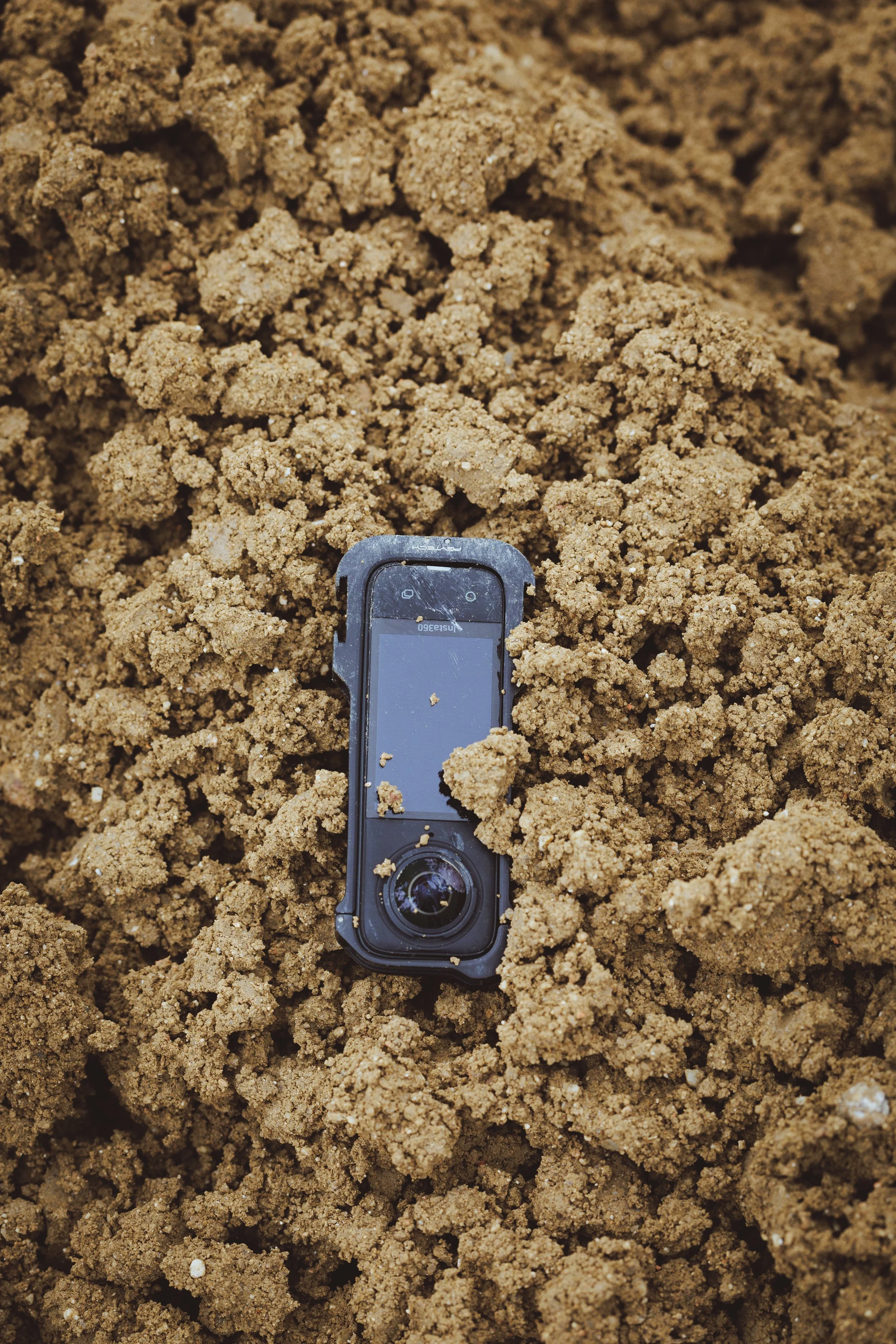 cámara de acción Insta360 enterrada en la tierra de un circuito 