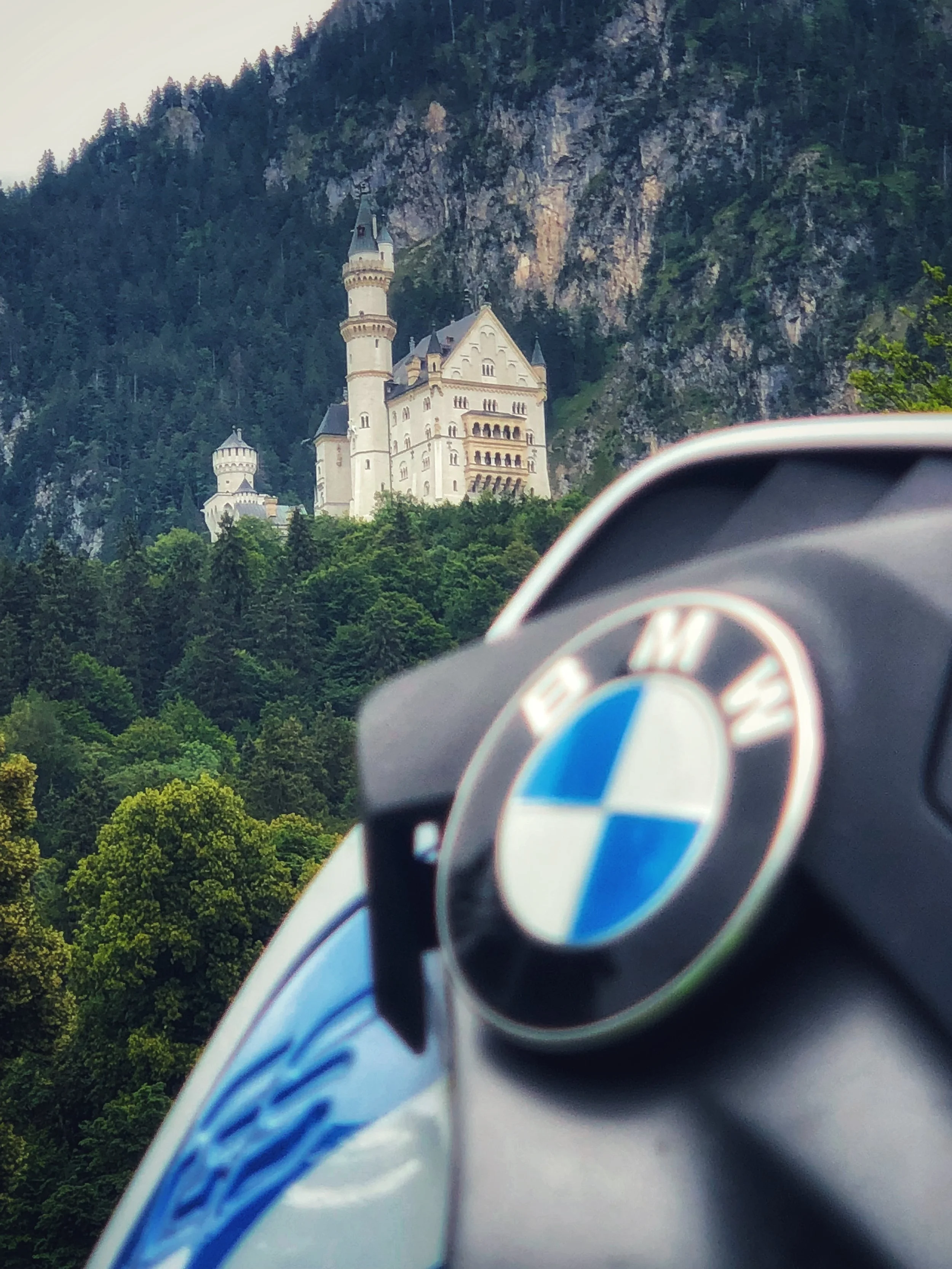 Castillo en una montaña, visto desde un coche BMW con el logotipo visible en el volante.