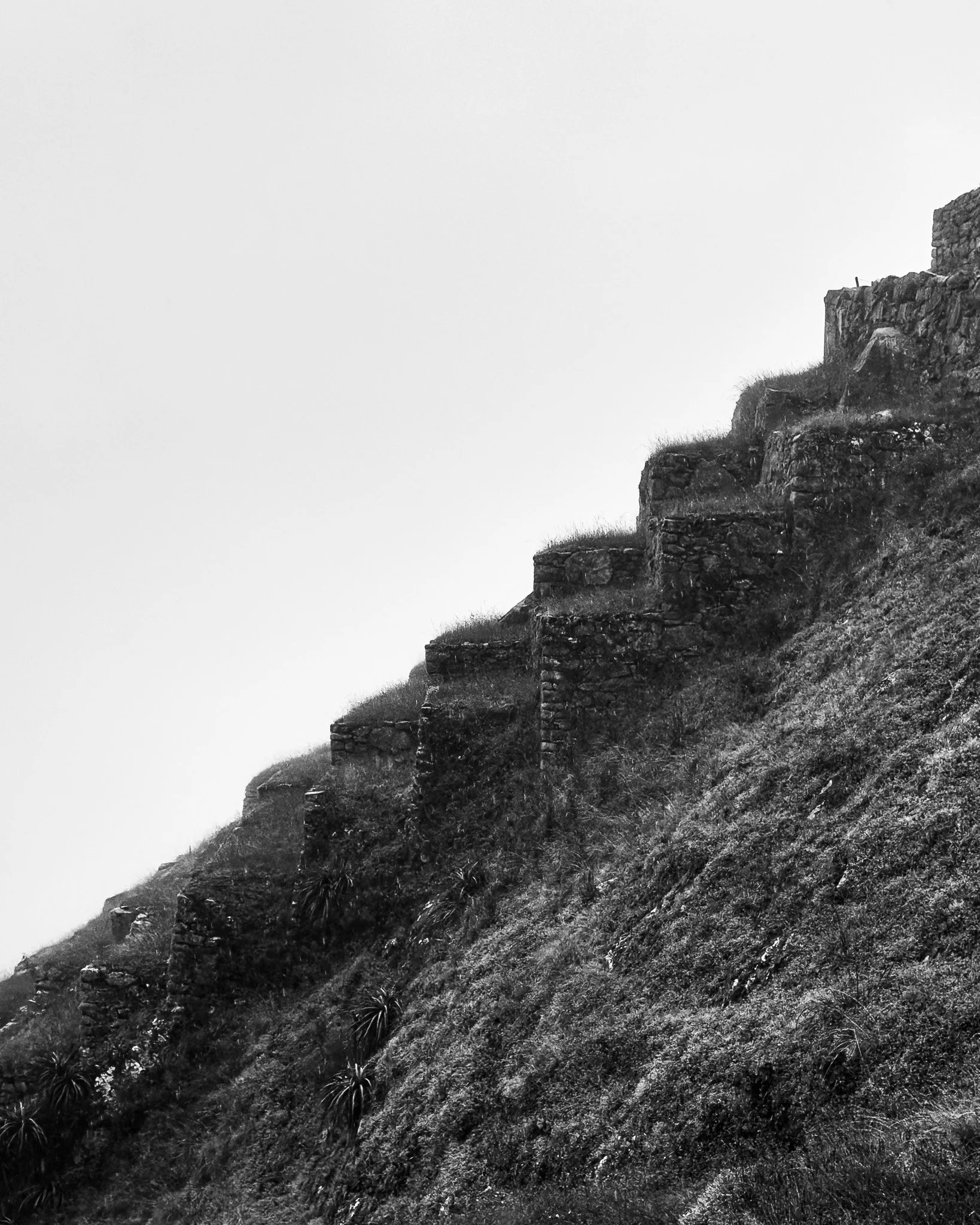 Black and white photo of ancient stone steps built into a steep hillside or mountain.