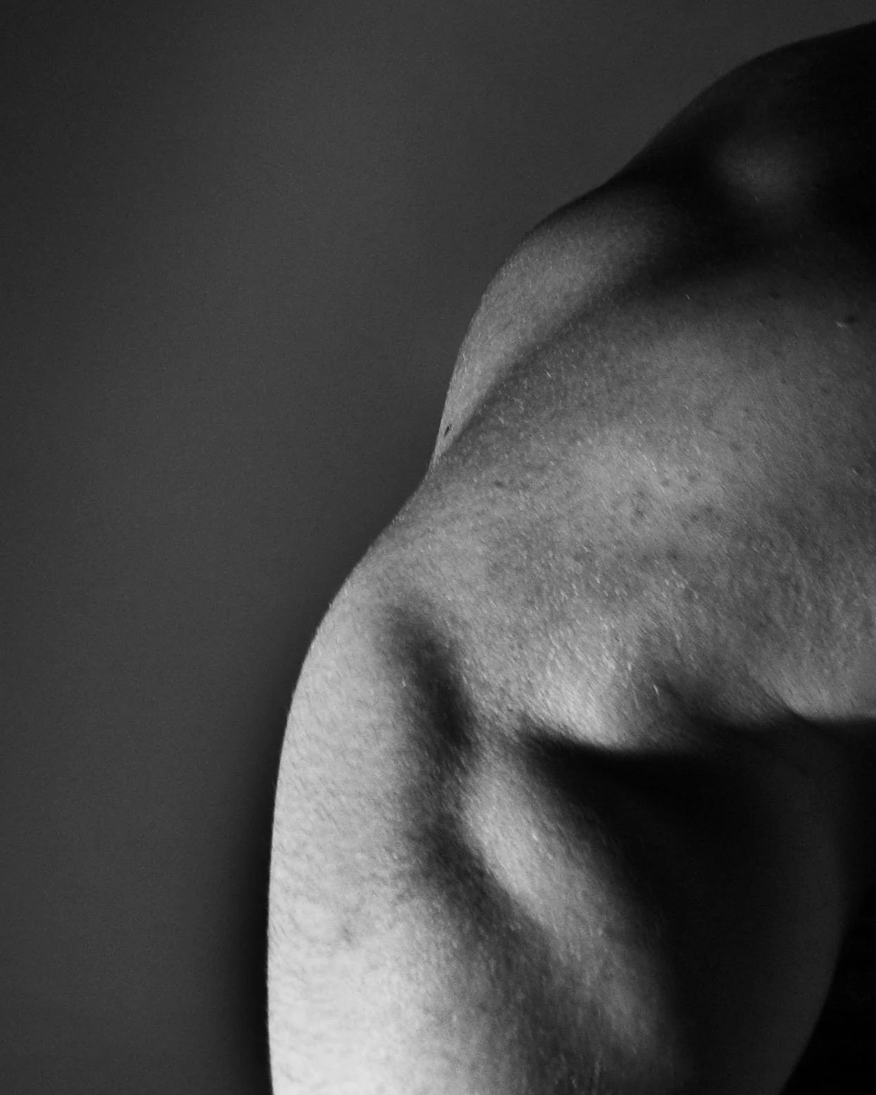 Close-up of an African American person's shoulder and upper back in black and white