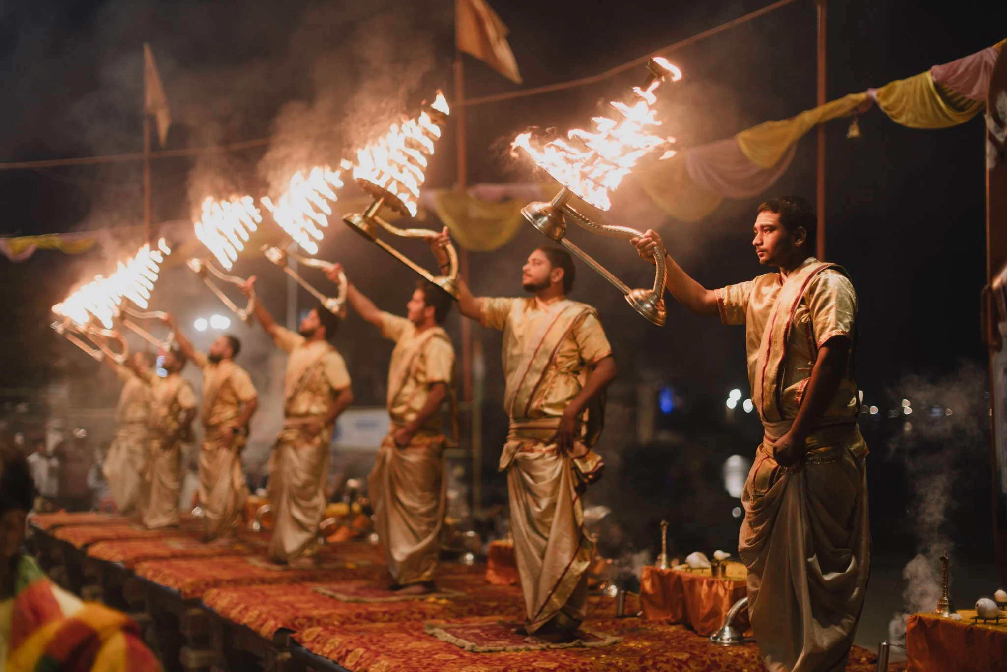 Men performing a traditional fire dance during a cultural event at night.