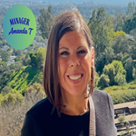 A woman with shoulder-length brown hair smiling outdoors with trees and a blue sky in the background
