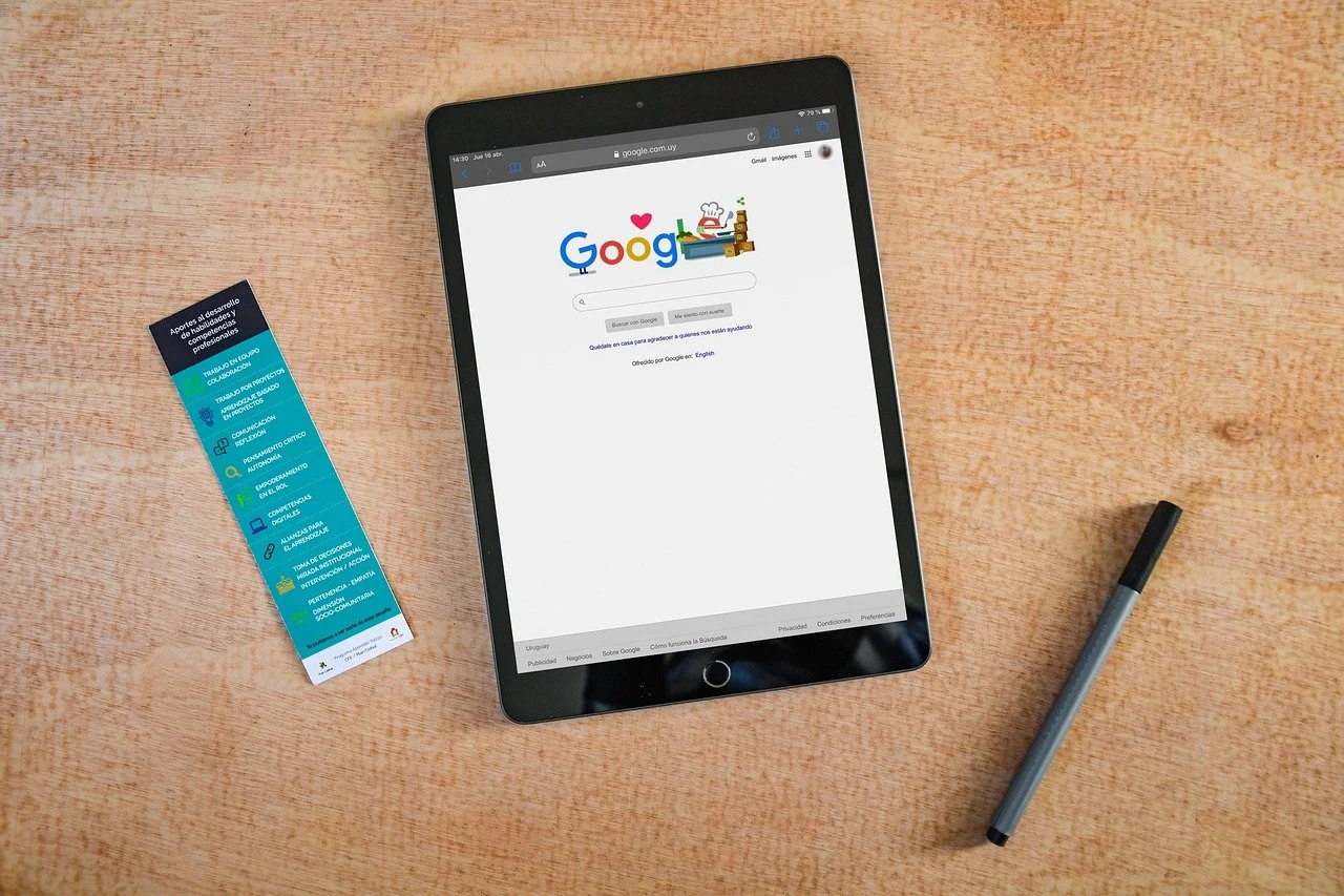 An iPad displaying the Google search homepage on a wooden desk, referencing digital marketing.