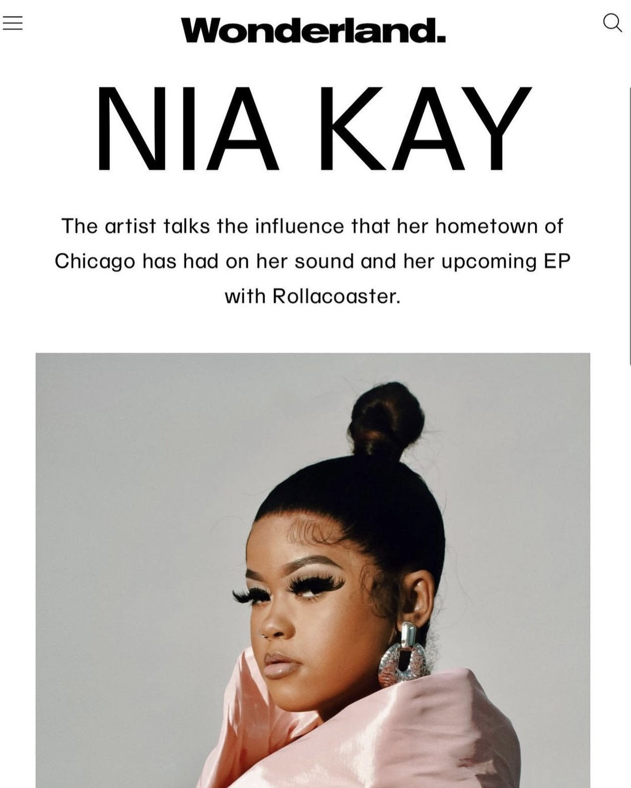 An online article featuring artist Nia Kay with a close-up photo of her with styled hair, dramatic makeup, and large statement earrings.