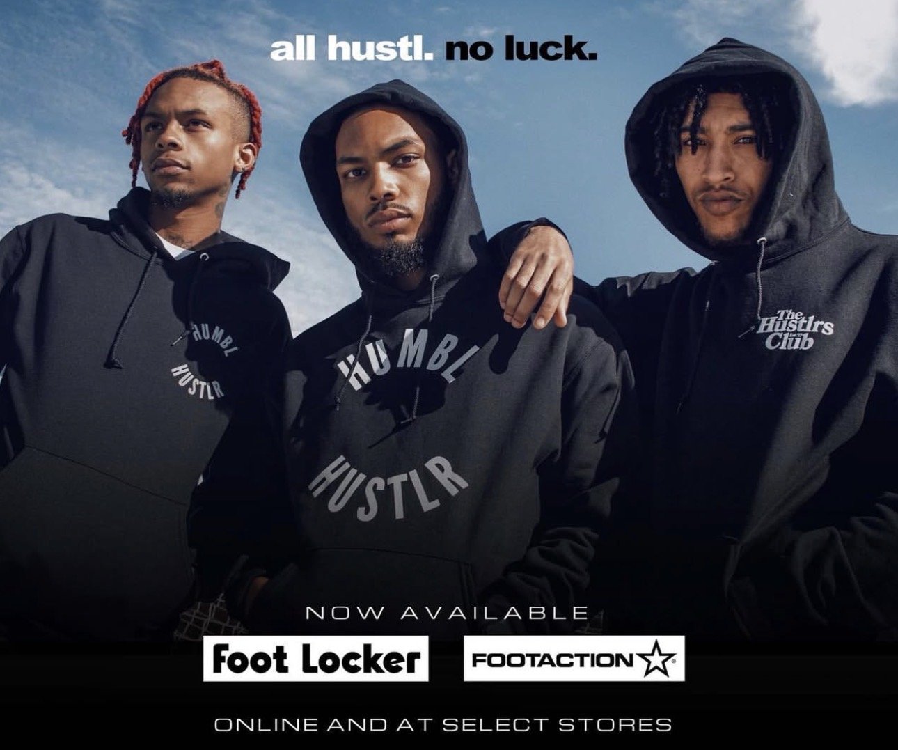 Three young men wearing black hooded sweatshirts with 'HUMBLR HUSTLR' logos, posing outdoors under a blue sky with clouds, promotional image for Foot Locker and Footaction.