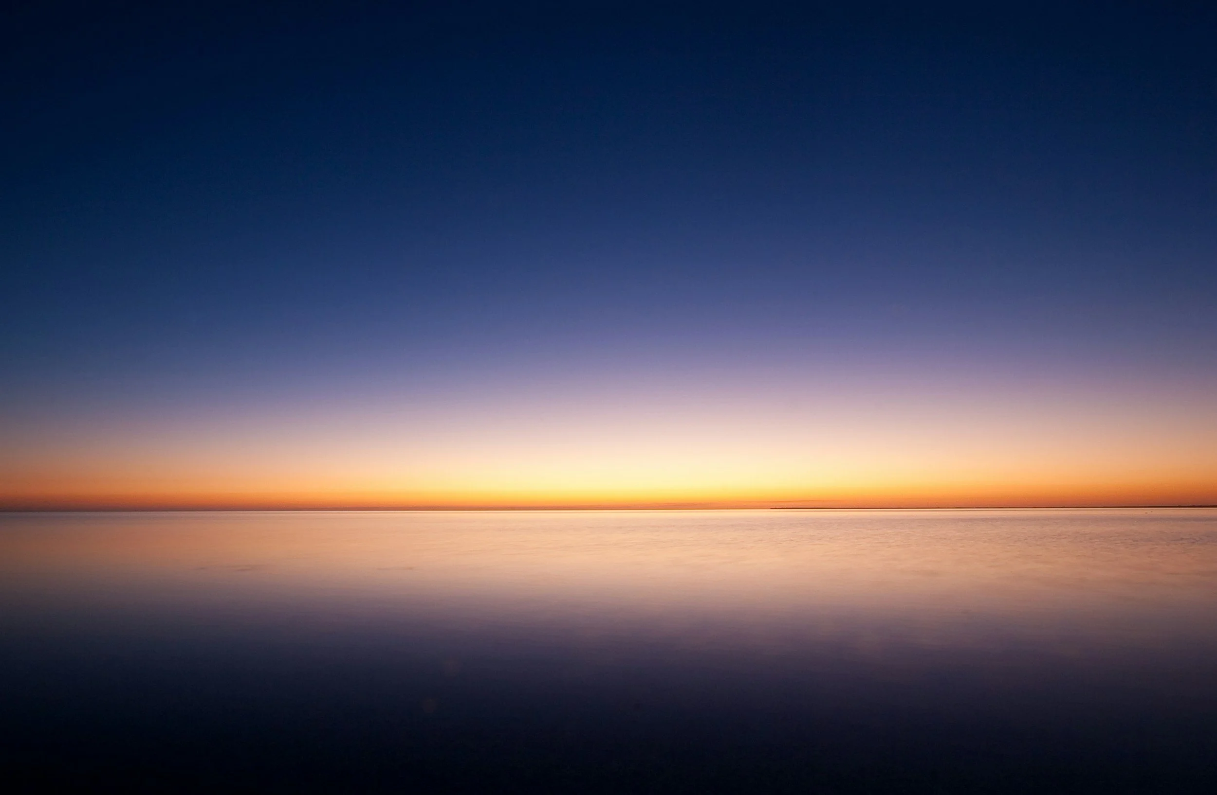 Warm golden sunset with a blue-to-dark-blue gradient sky, used to represent attachment-based therapy.