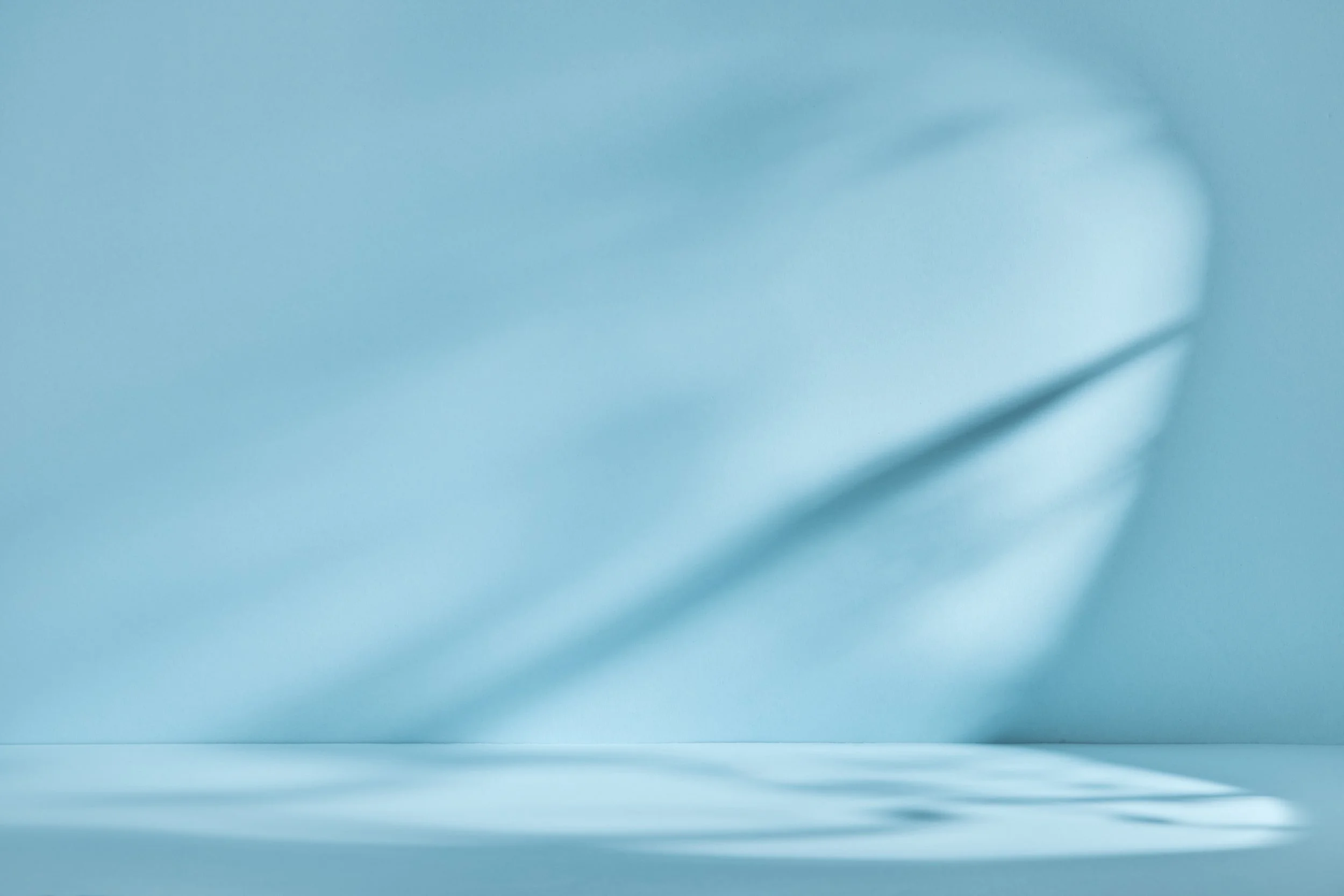 Minimal empty blue room with soft shadows, used on the Approach page.