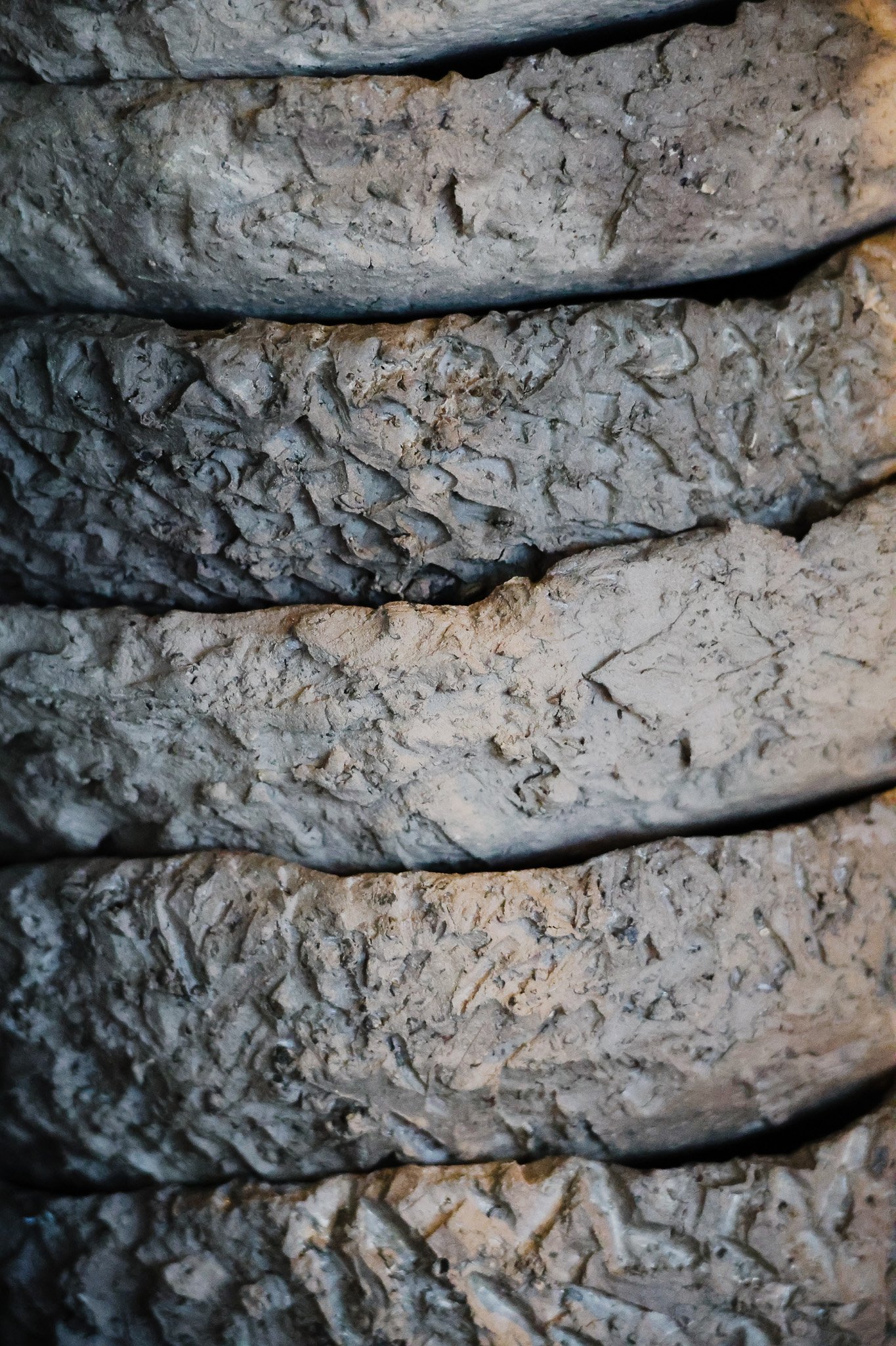 Close-up of several layers of textured gray cement blocks or bricks stacked together.