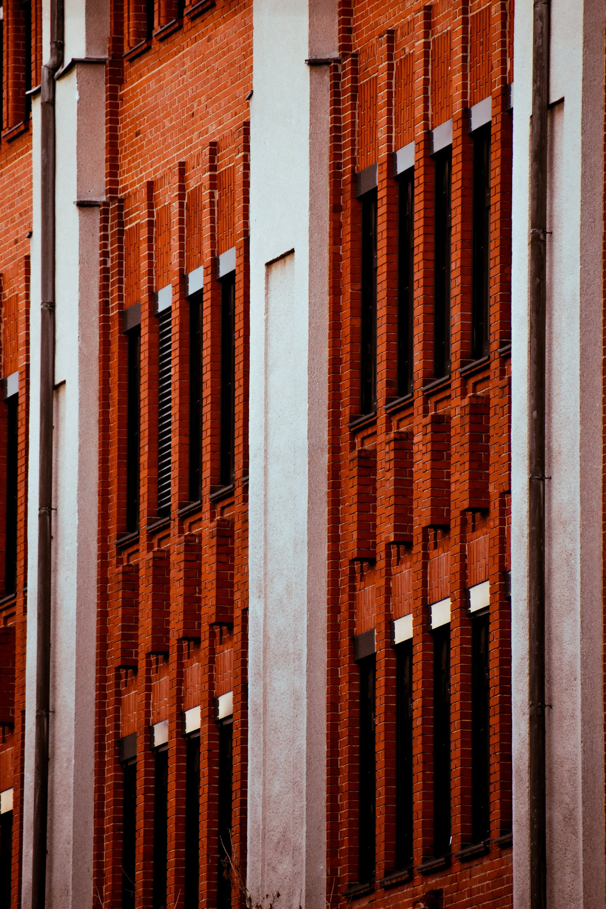 Close-up of a red brick building with multiple windows.