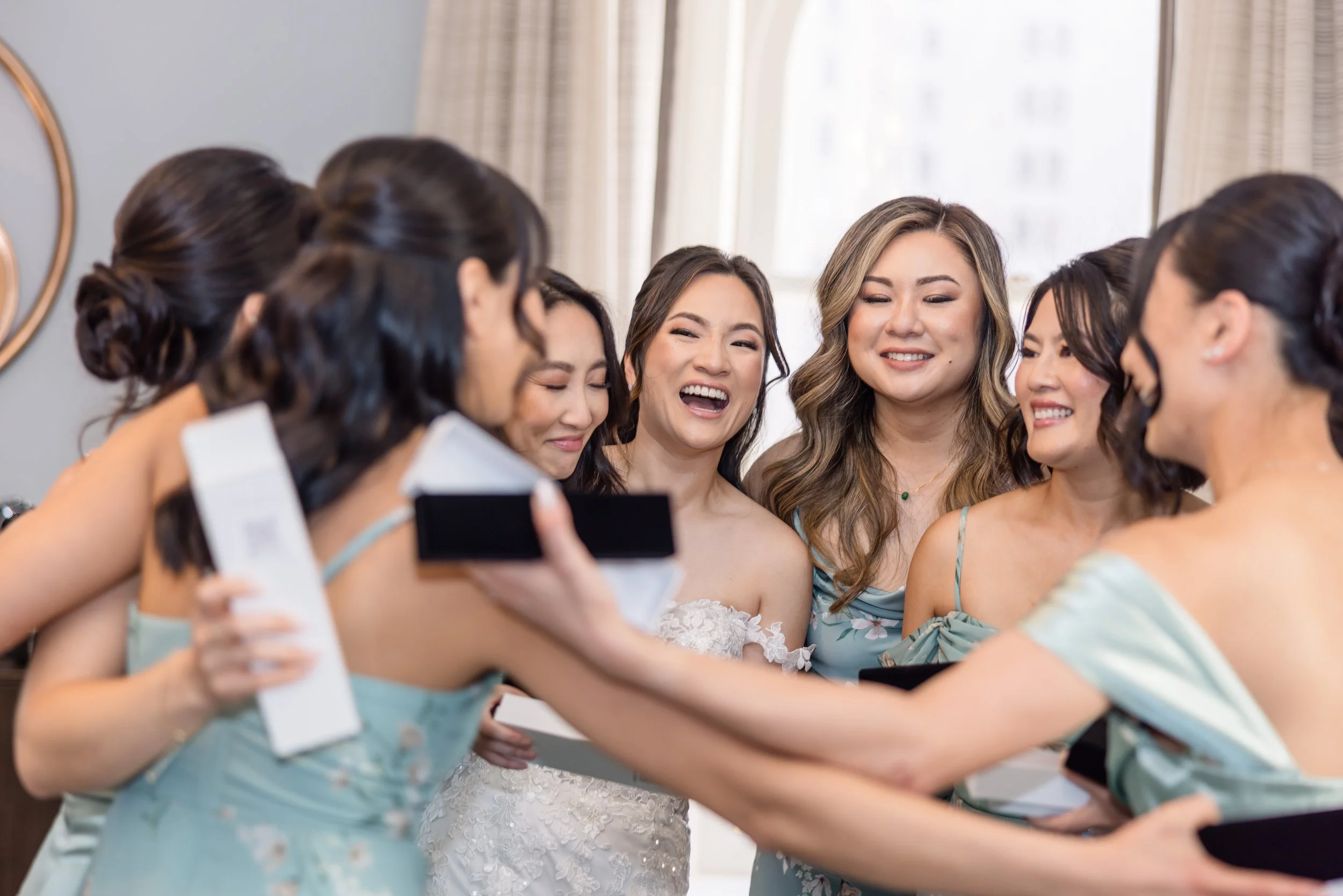 Bride hugging bridesmaids with custom pearl jewelry gift boxes by San Francisco custom bridal jewelry Delphiq Jewelry