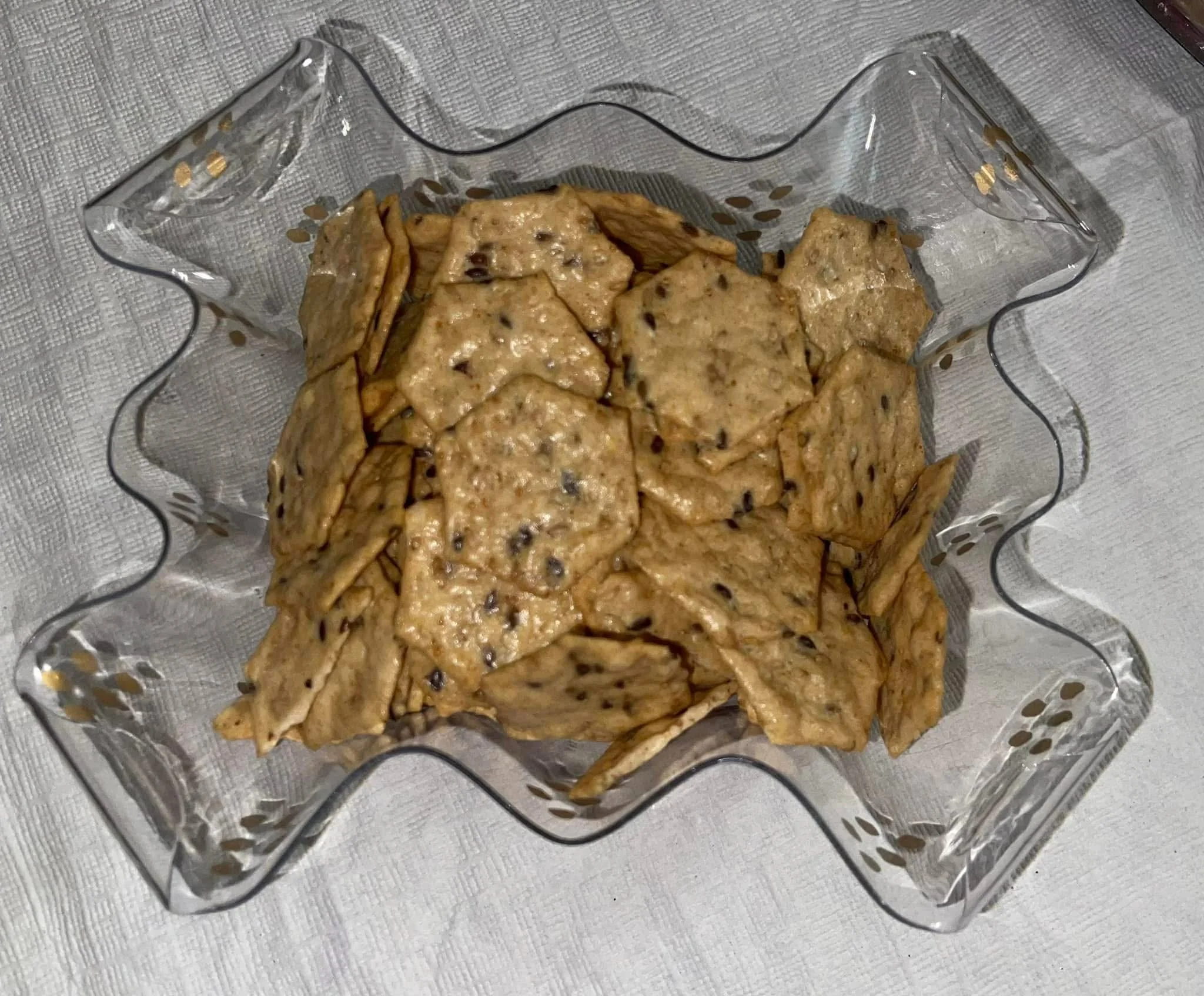 Overhead view of multi seed crackers in a glass decorative dish