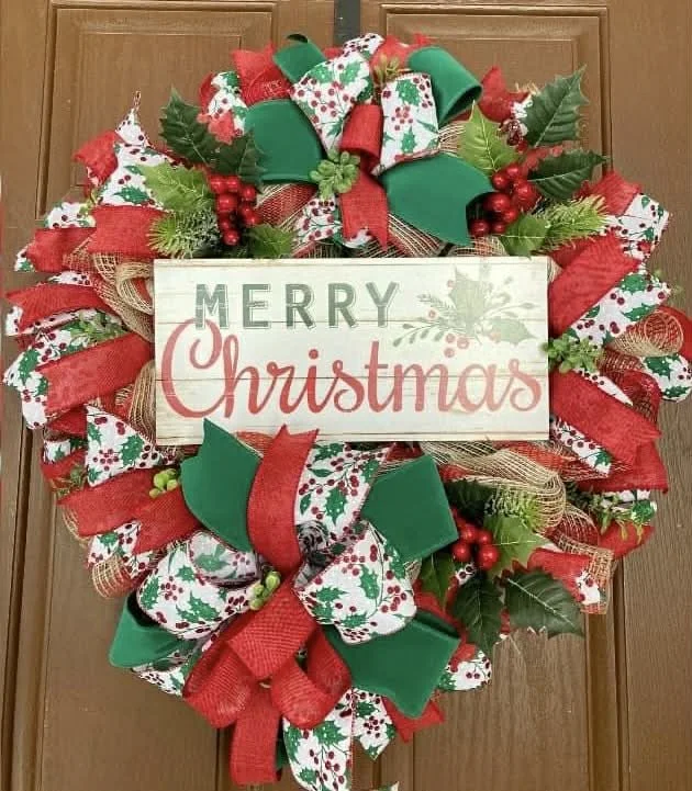 Christmas theme wreath, ribbon and tulle varying patterns with sign saying merry christmas.