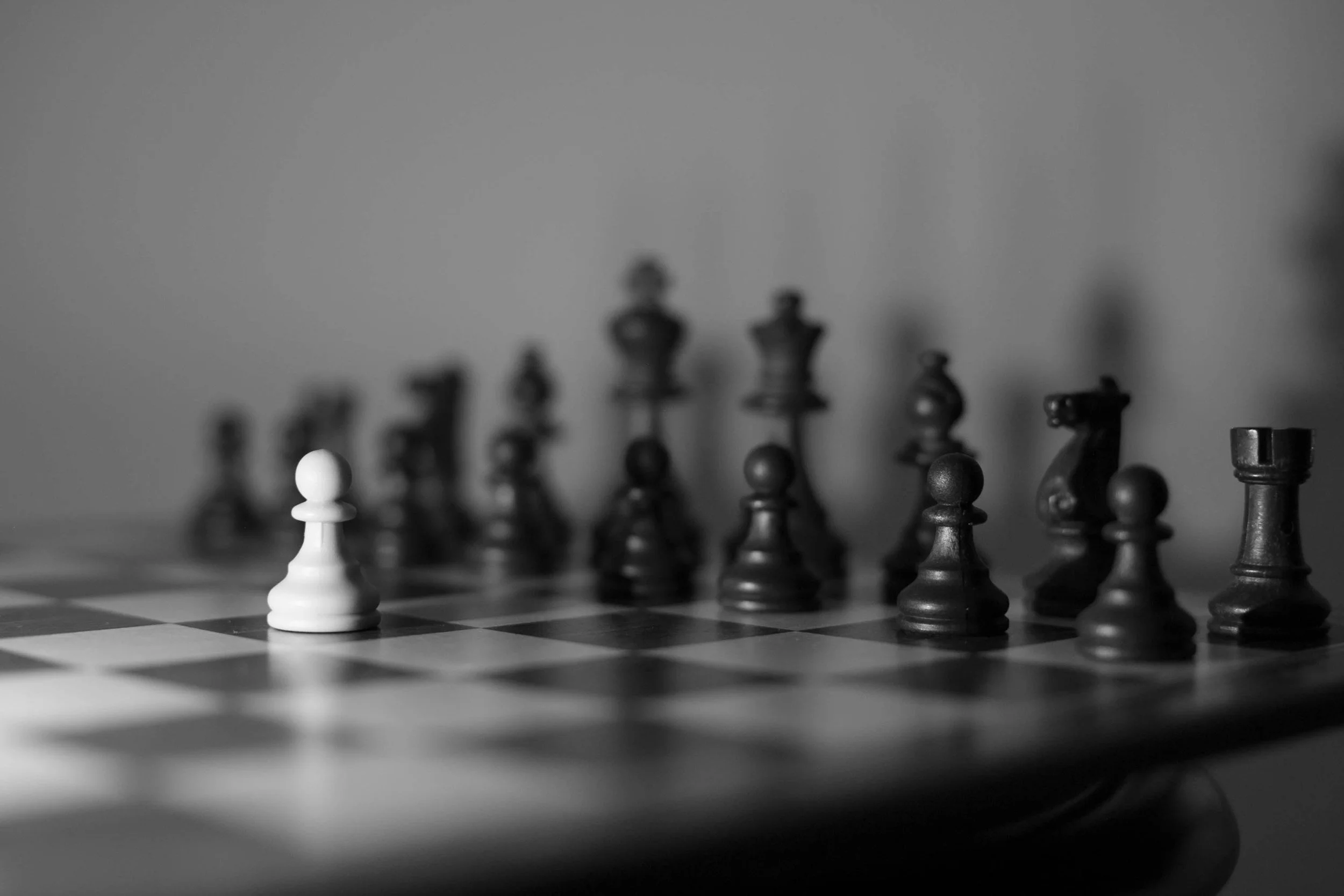 An advanced pawn isolated on the board, directly opposing the enemy’s full complement of chess pieces.