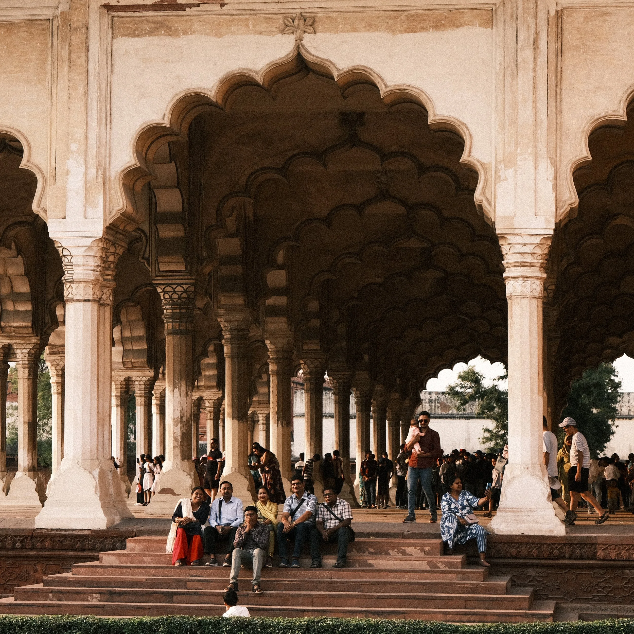 Personas sentadas en uno de los salones del Fuerte de Agra