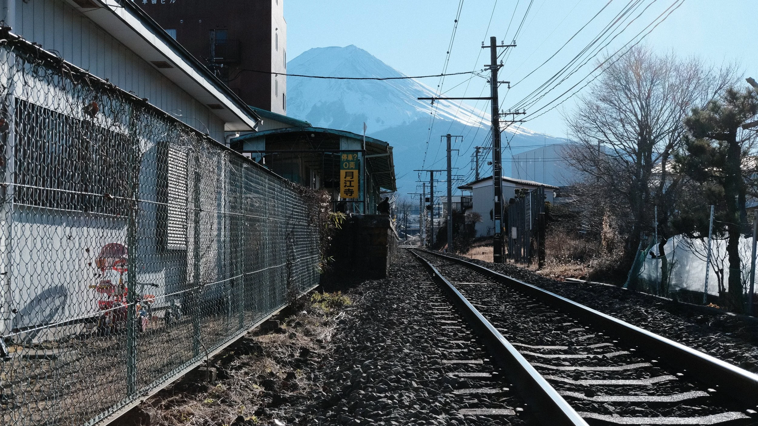 Estación y vías de tren con el Monte Fuji al fondo.