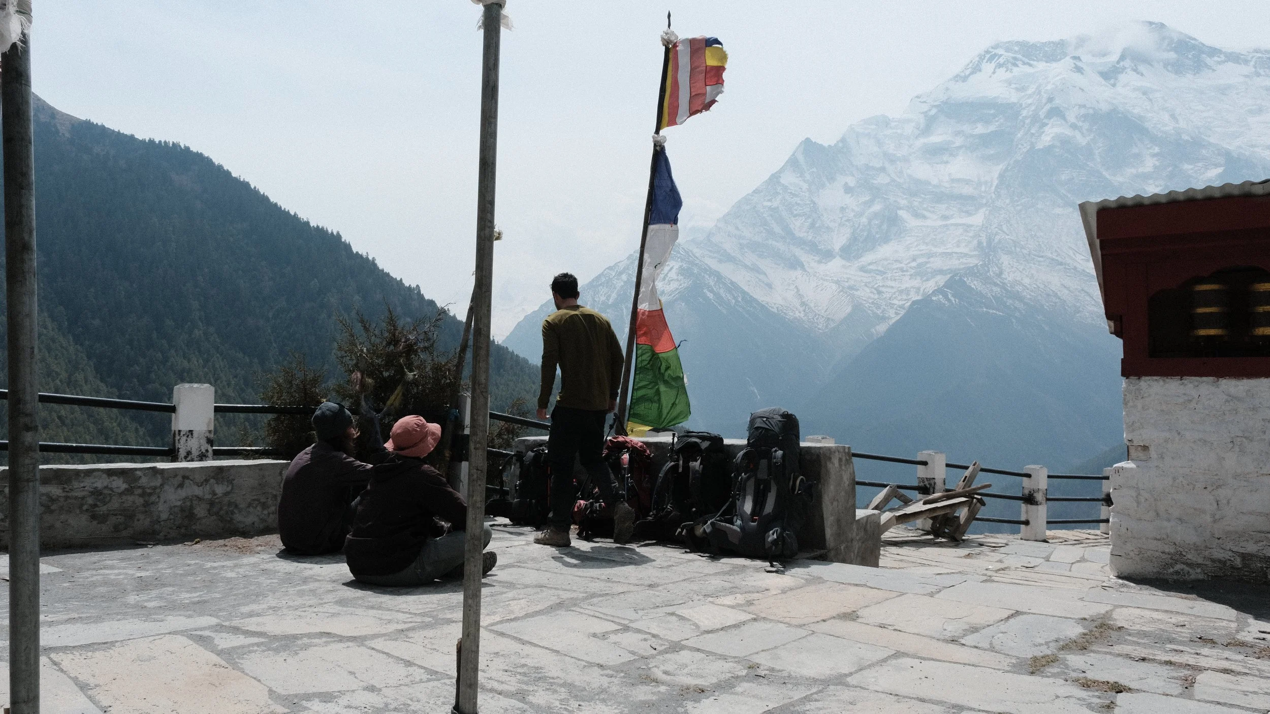 Personas descansando en el circuito de Annapurna con los Himalayas al fondo