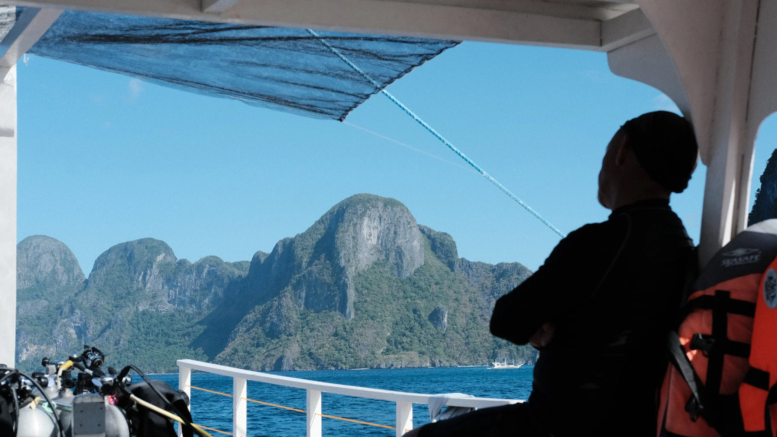 Persona recostada de espaldas en un bote de buceo en El Nido, Palawan