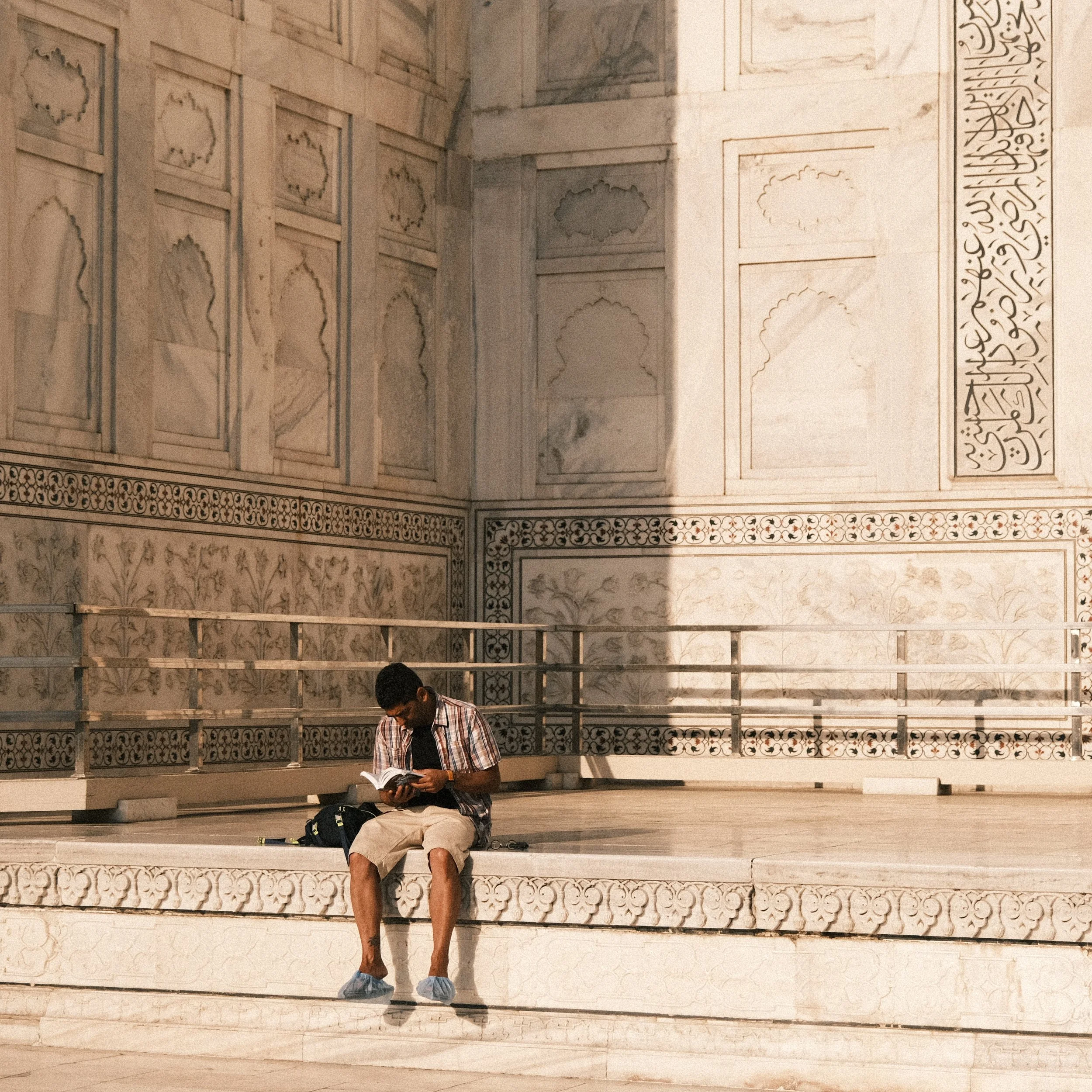 Hombre sentado leyendo en el Taj Mahal