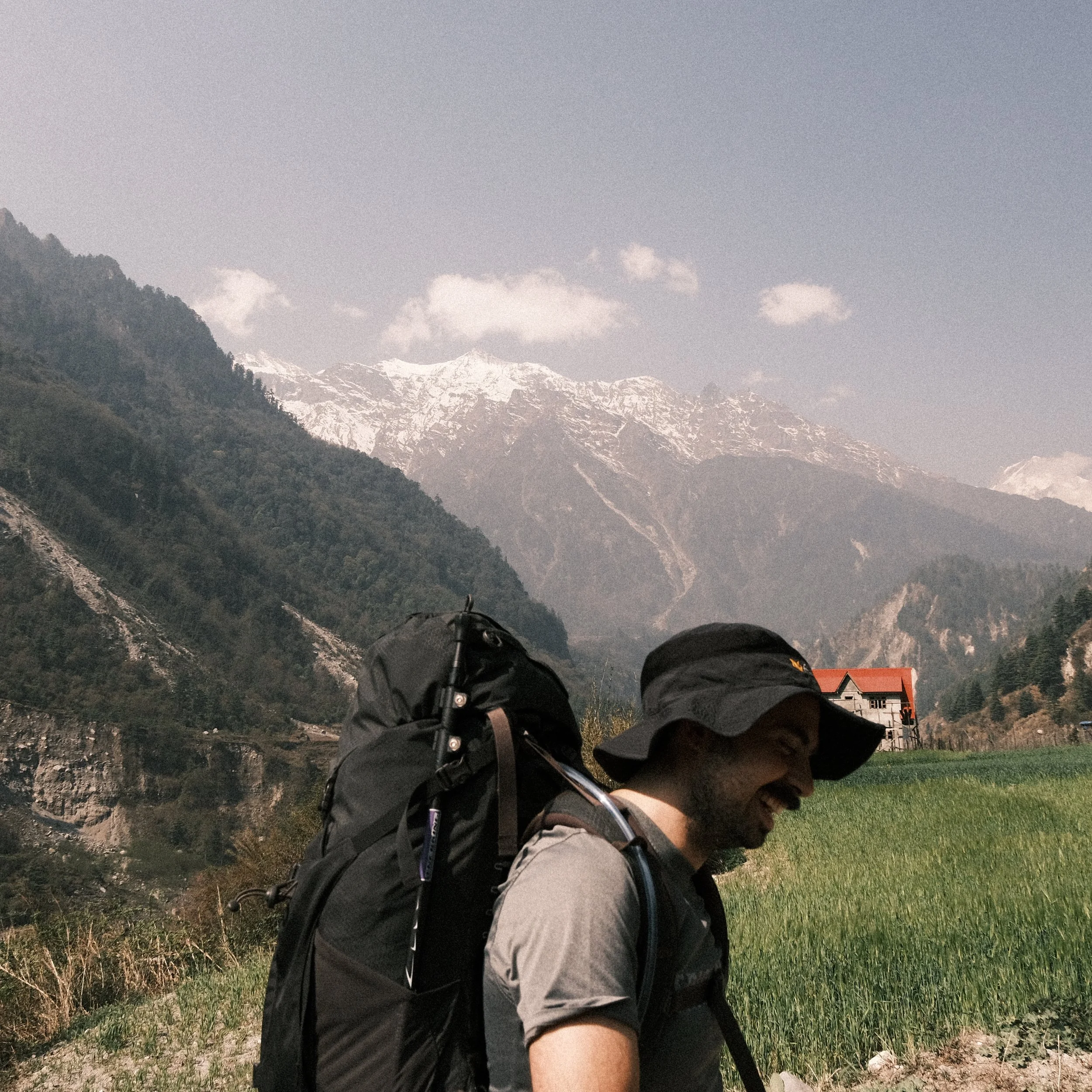 Hombre sonriente en el circuito de annapurna con montañas nevadas a lo lejos