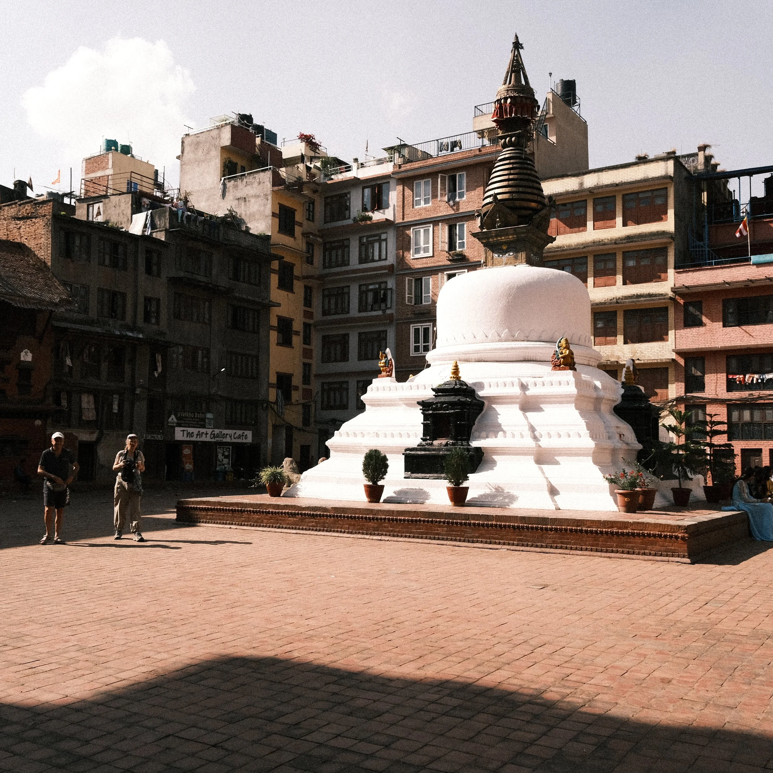 Turistas caminando al lado de una estupa en el centro de Katmandú