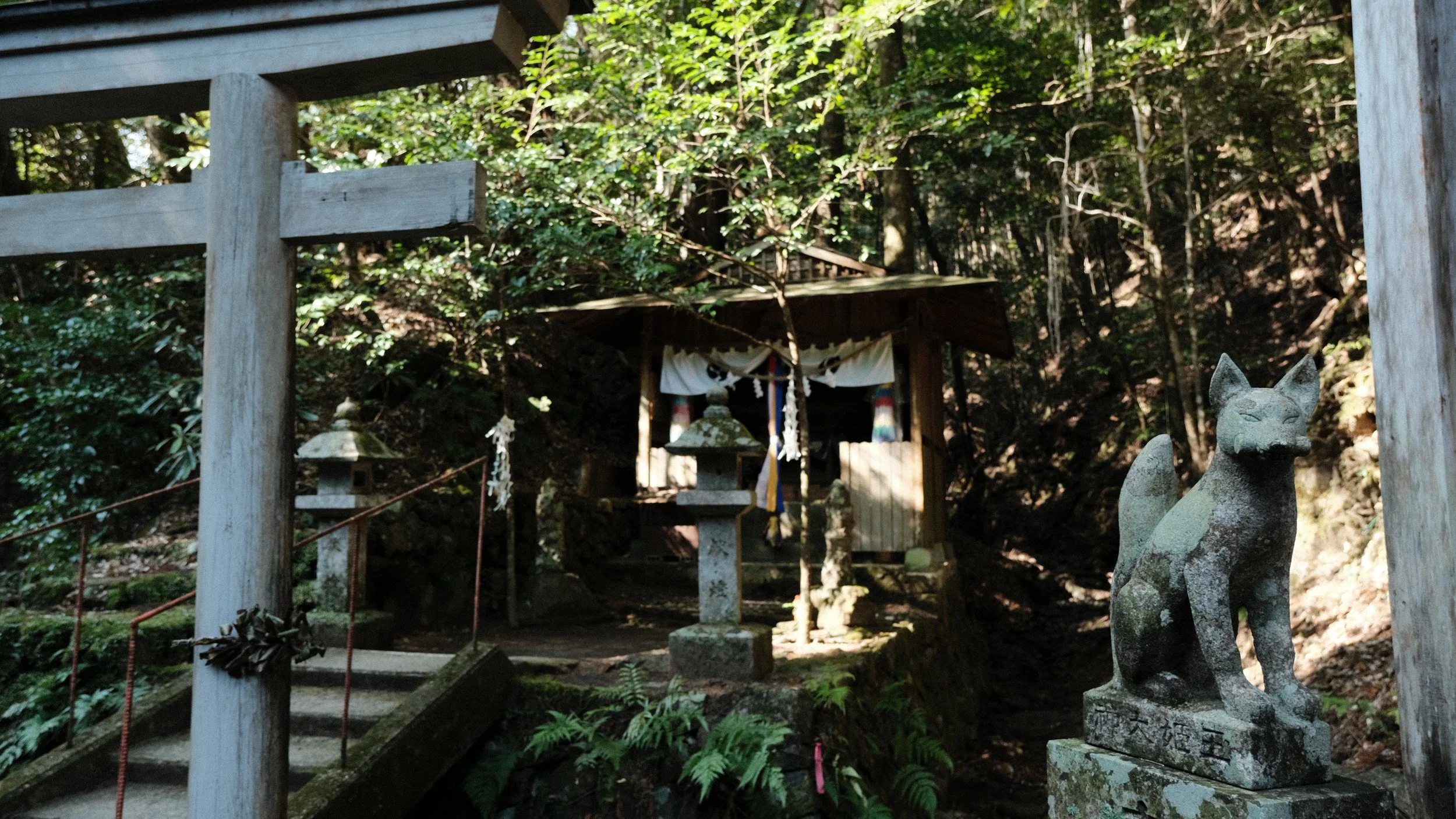 Pequeño santuario japonés con estatua de zorro.