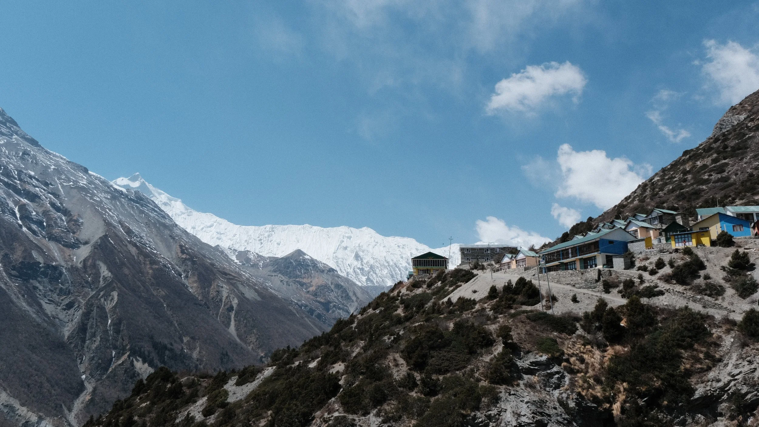 Casas con montañas al fondo en el circuito de Annapurna
