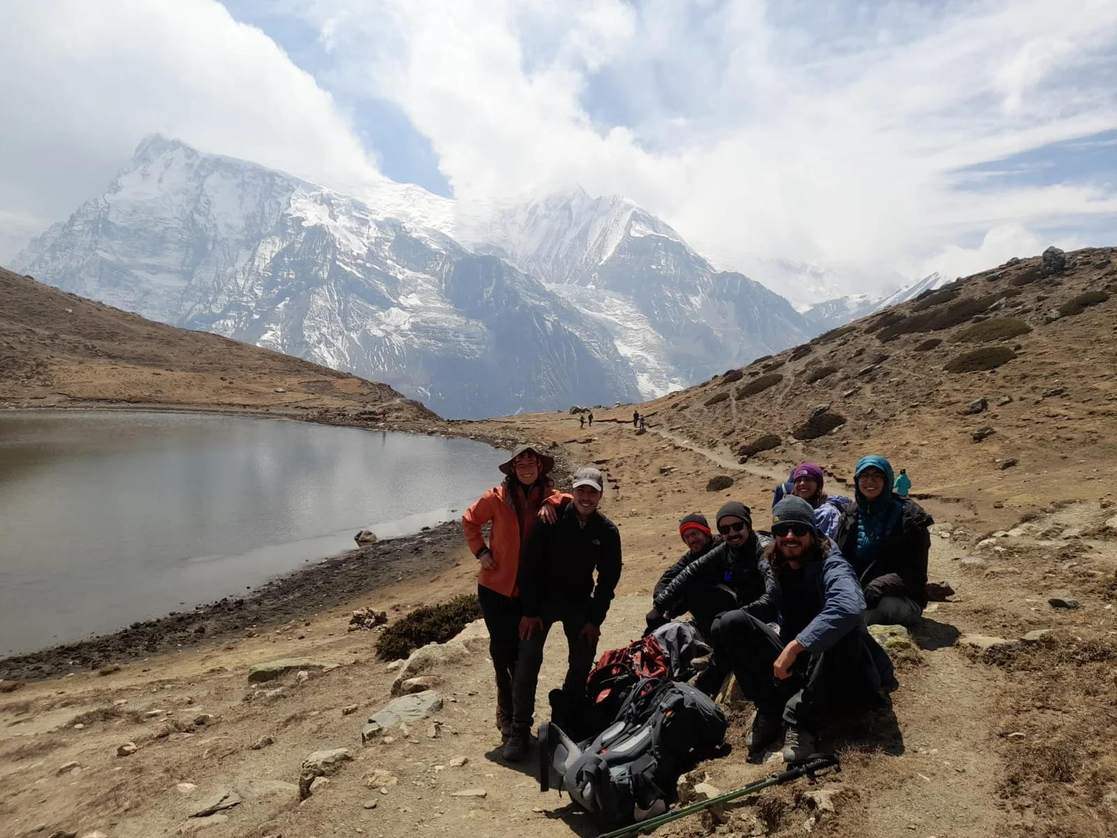 Personas descansando con montañas nevadas al fondo.