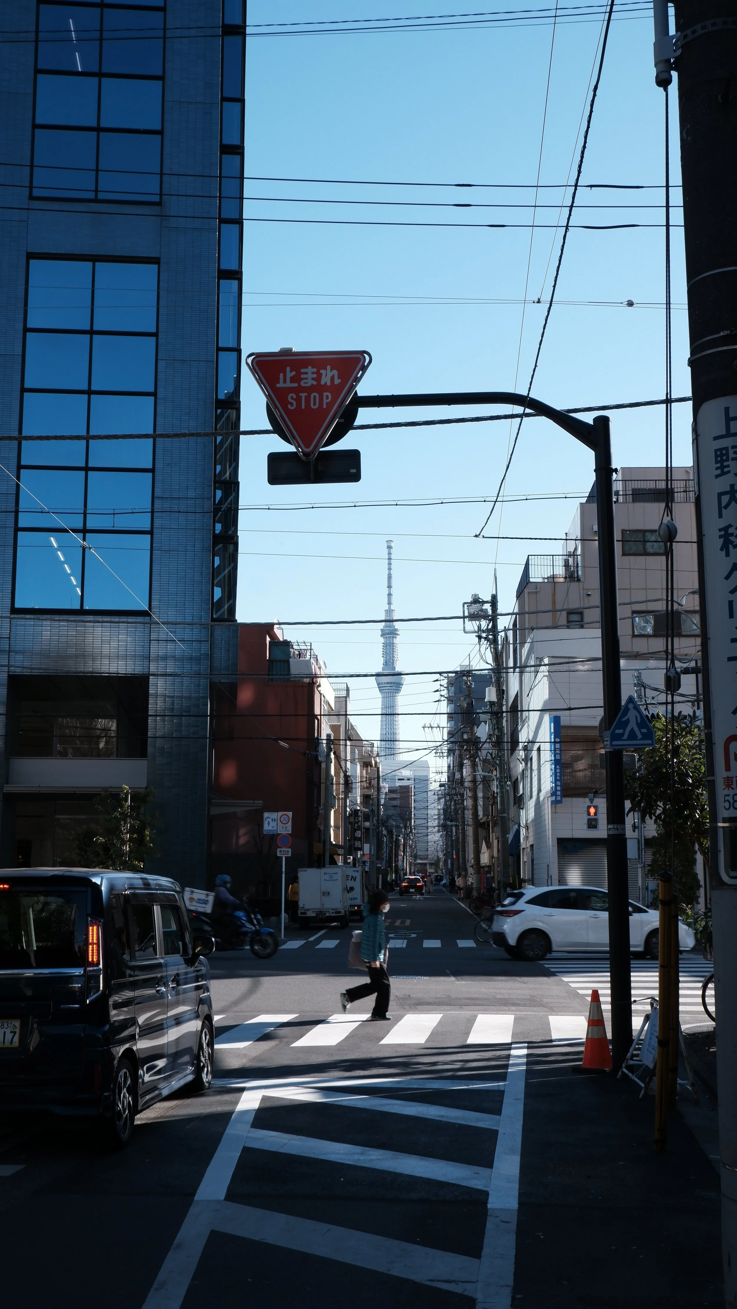 Una mujer corriendo hacia la oficina, con el Tokyo Skytree al fondo.