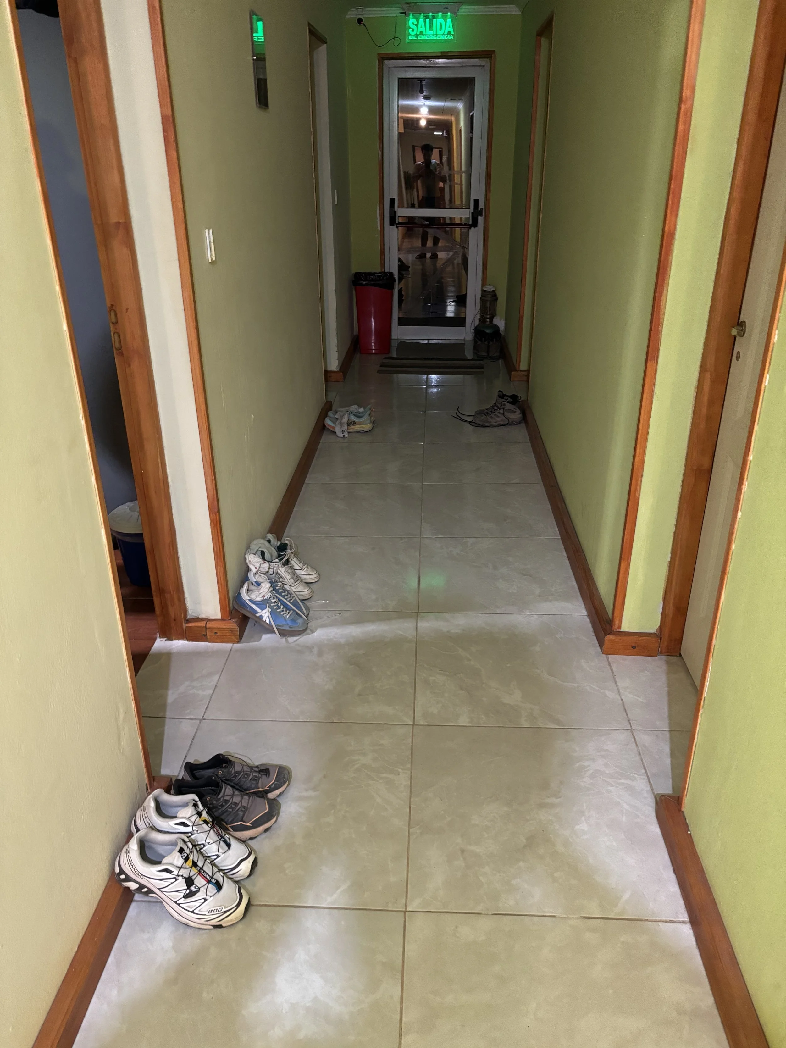 Pasillo en hostal de El Chaltén con zapatos de trekking