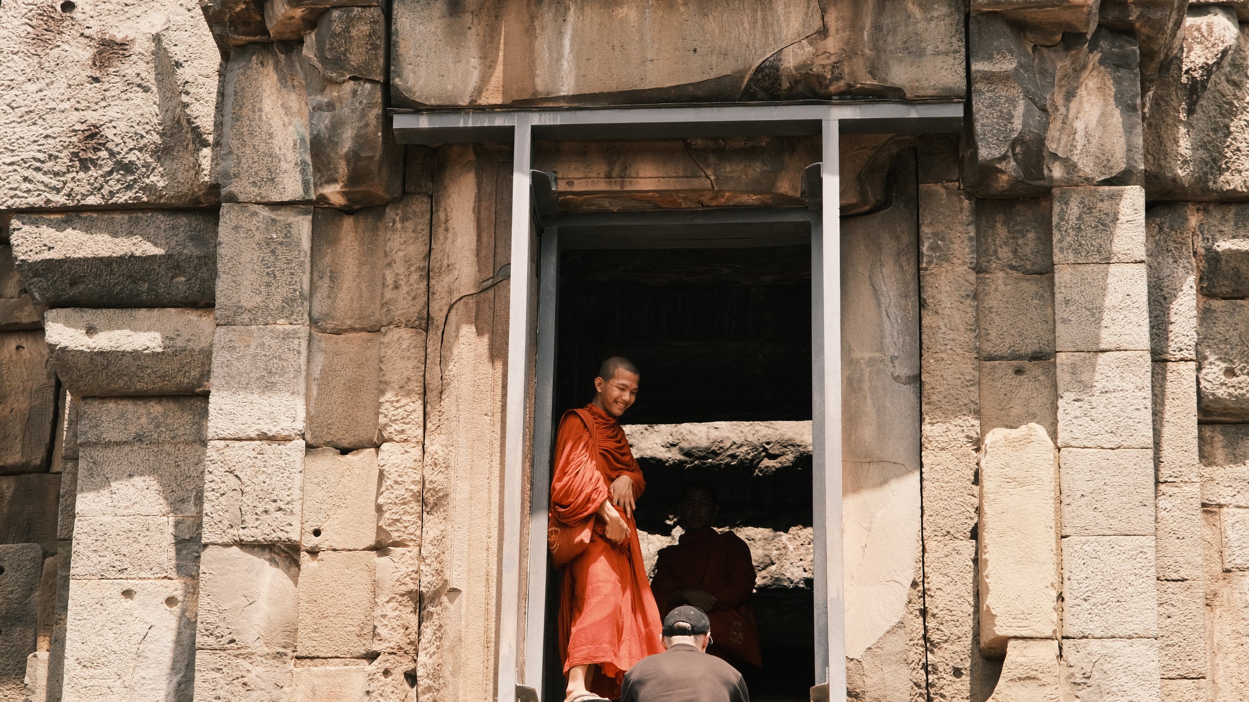Monje sonriendo en la entrada a una ruina en Angkor Wat