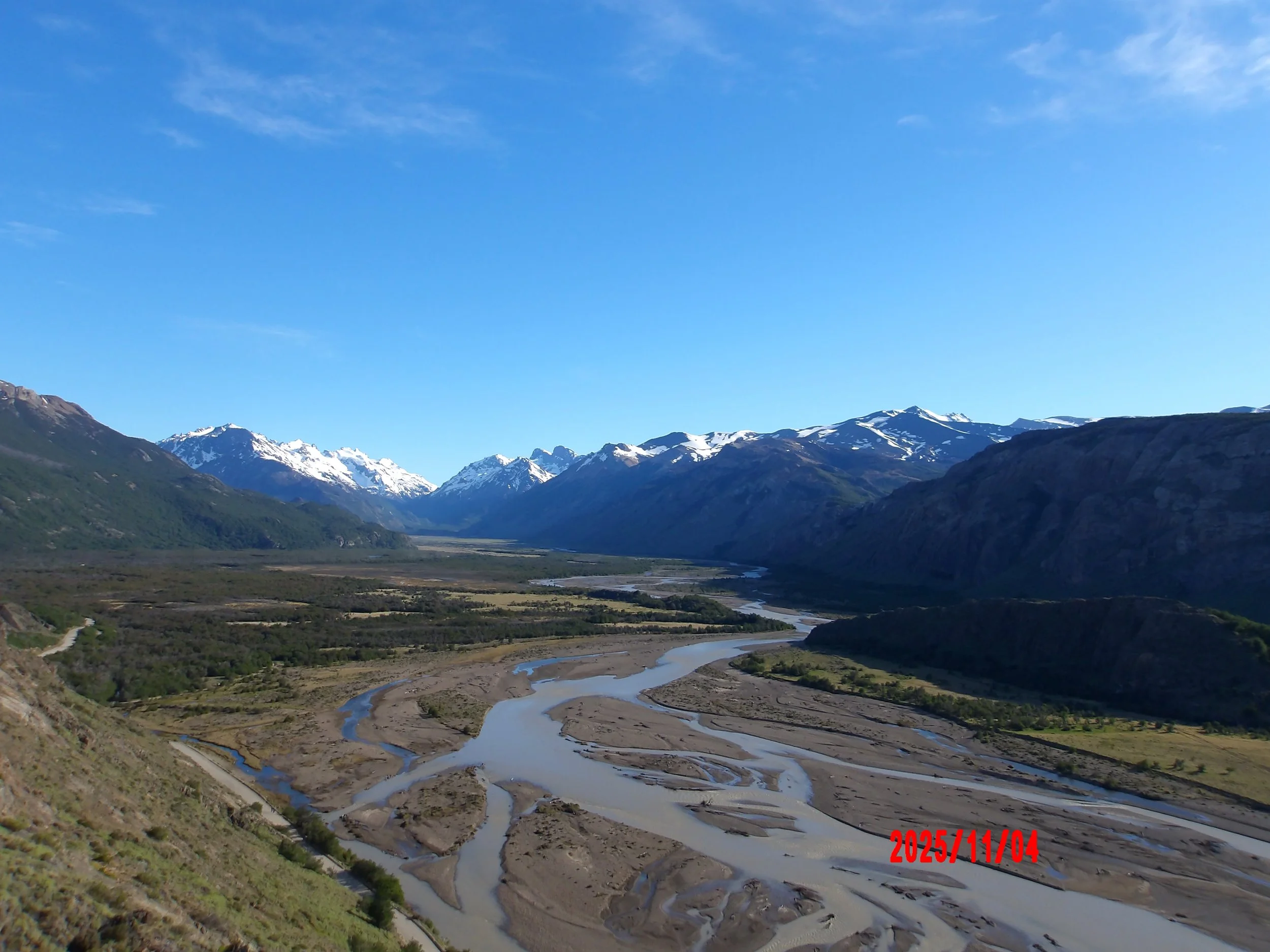 Vista de valle con ríos y montañas al fondo en Patagonia, Argentina.