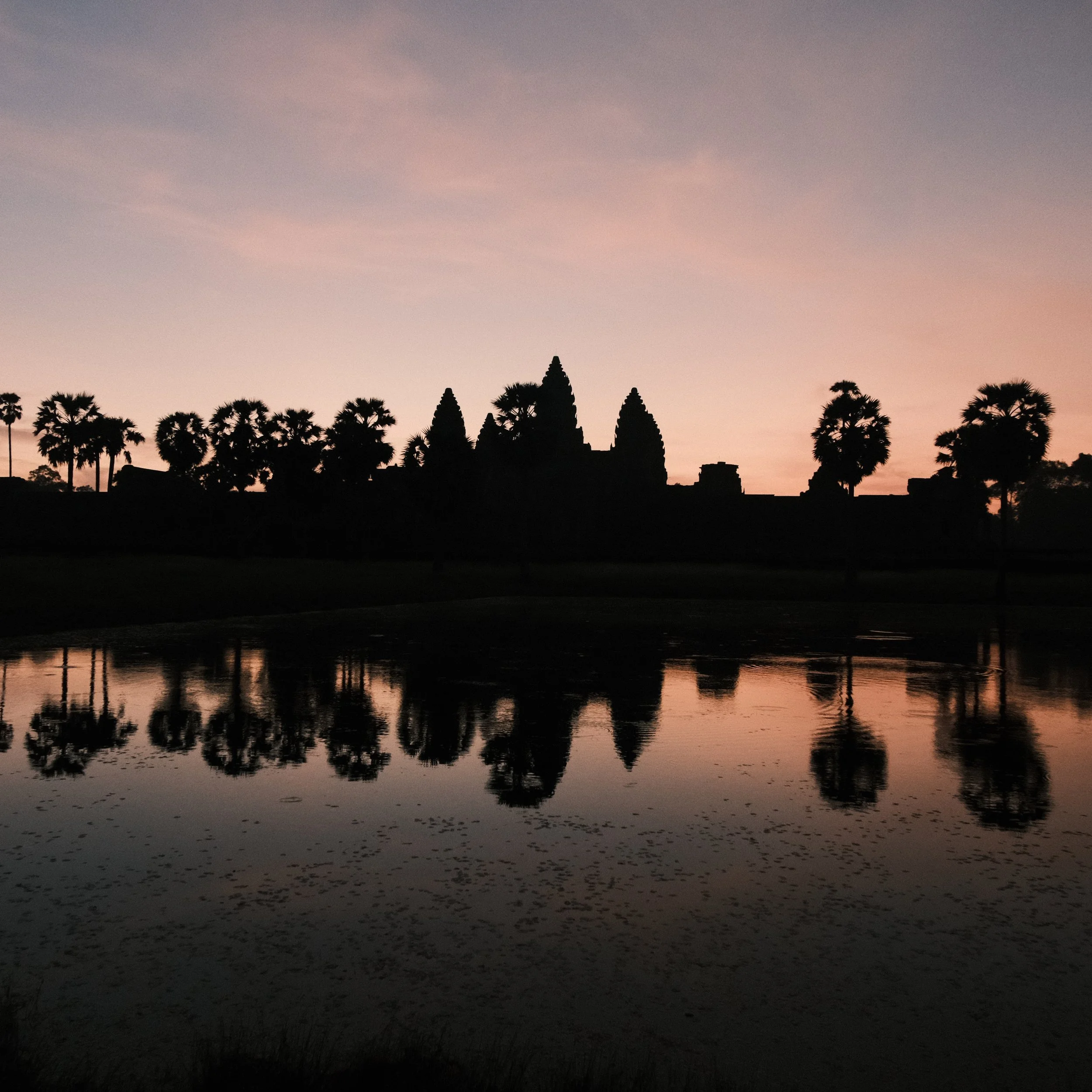 Templo de Angkor Wat al amanecer reflejado en una laguna
