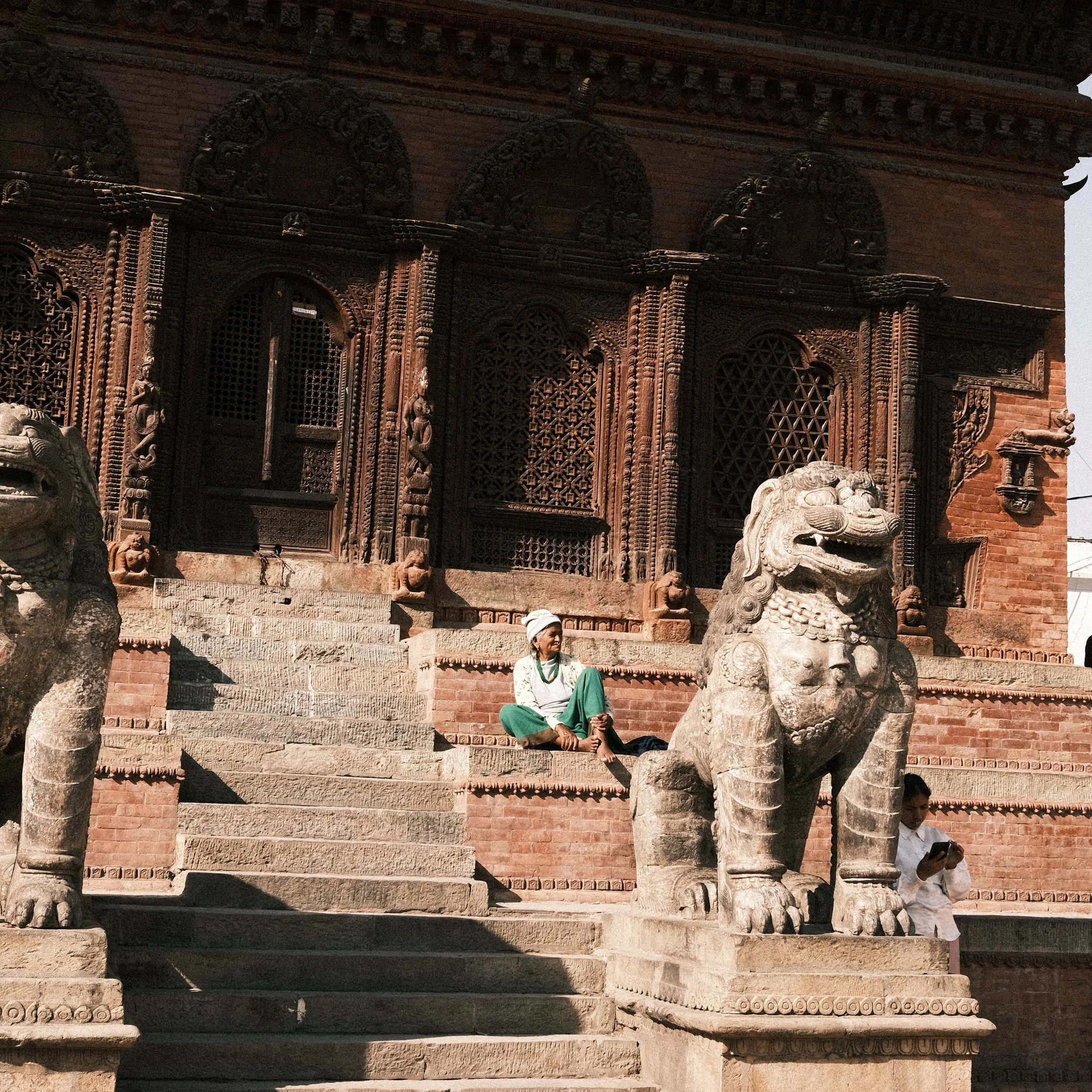 Mujer sentada en la entrada a un templo en la Plaza Durbar