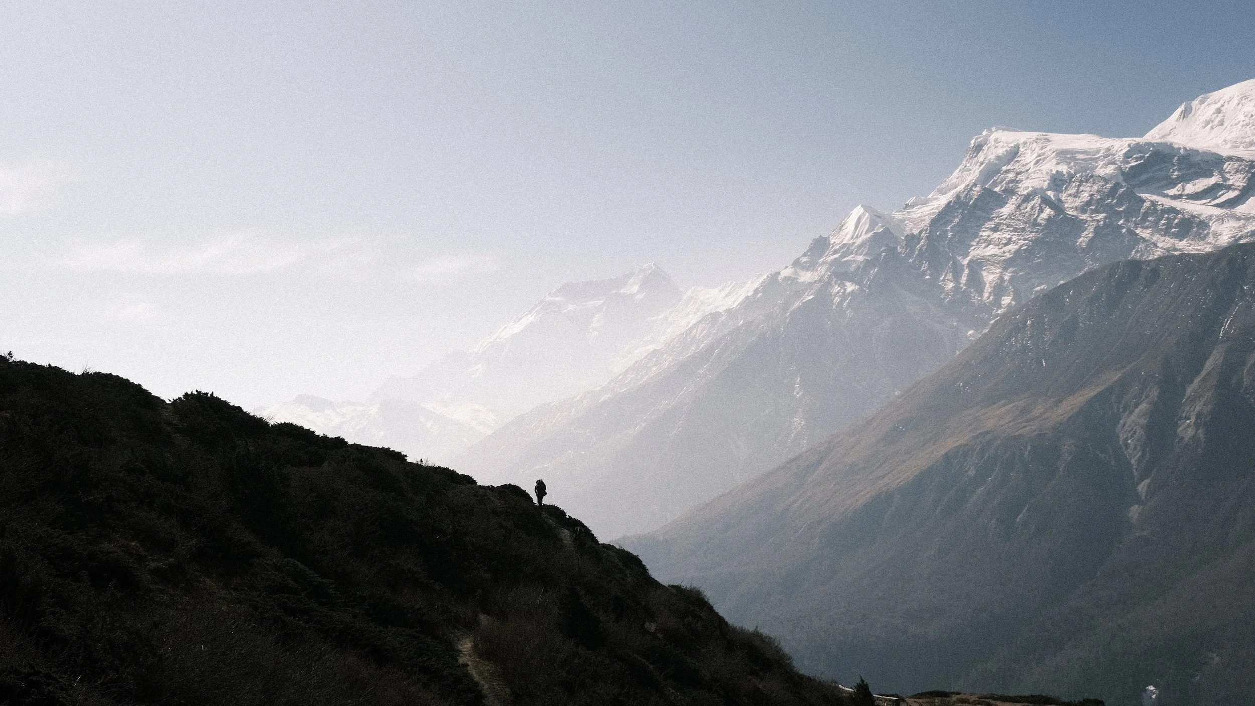 Persona con los Himalayas al fondo en el circuito de Annapurna