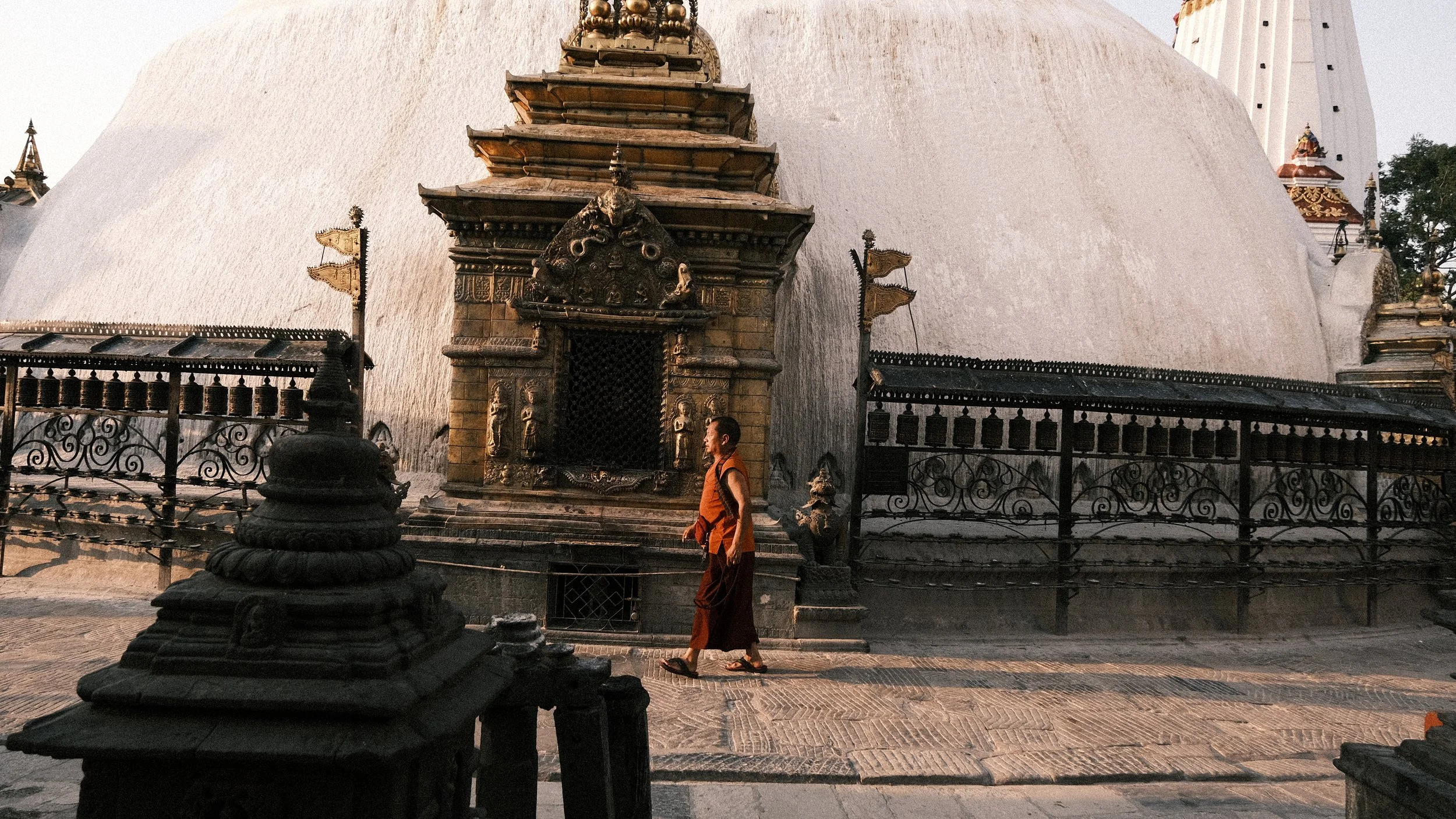 Hombre caminando alrededor de una estupa en Katmandú
