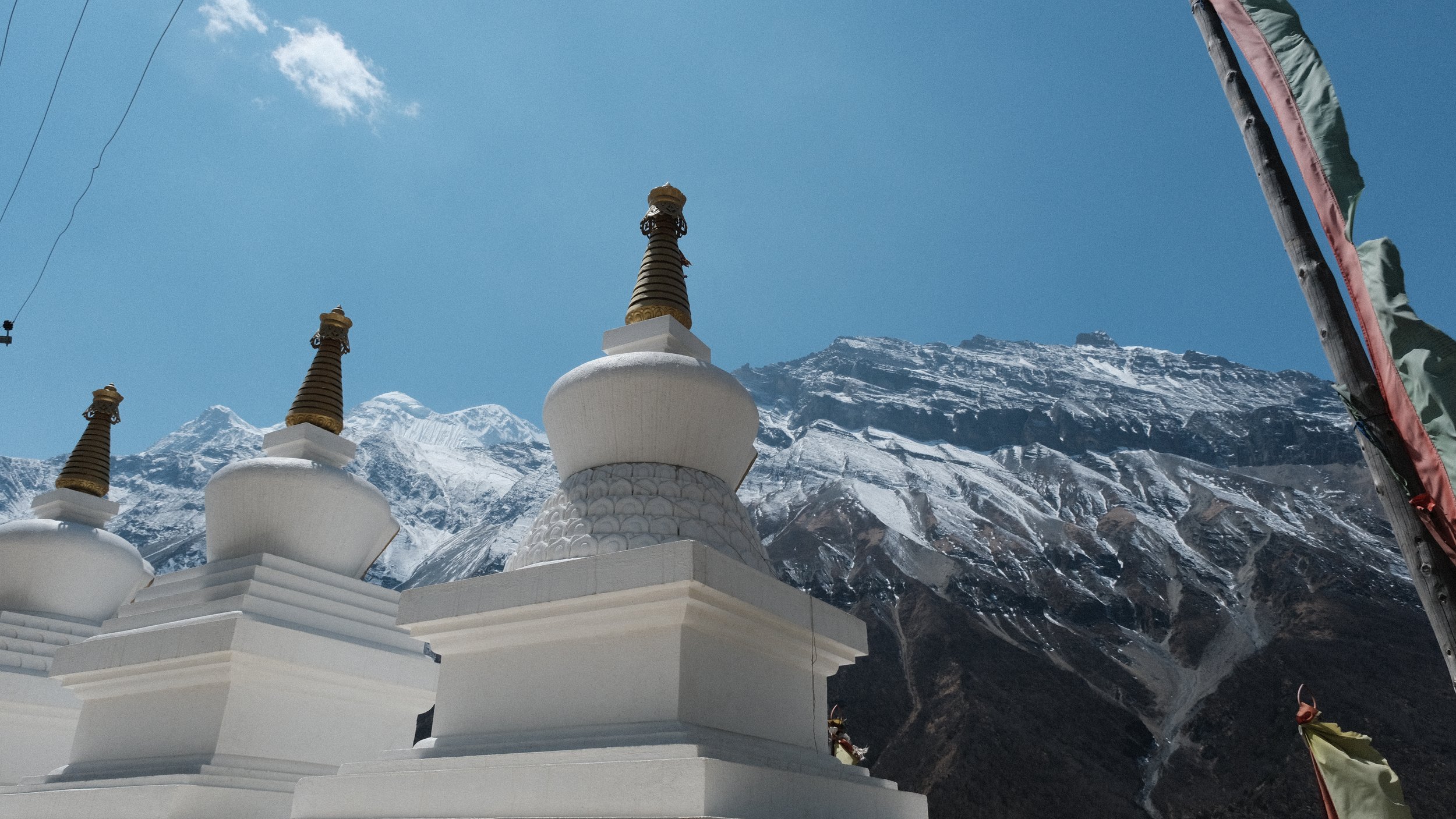 Estupas con montañas nevadas al fondo.