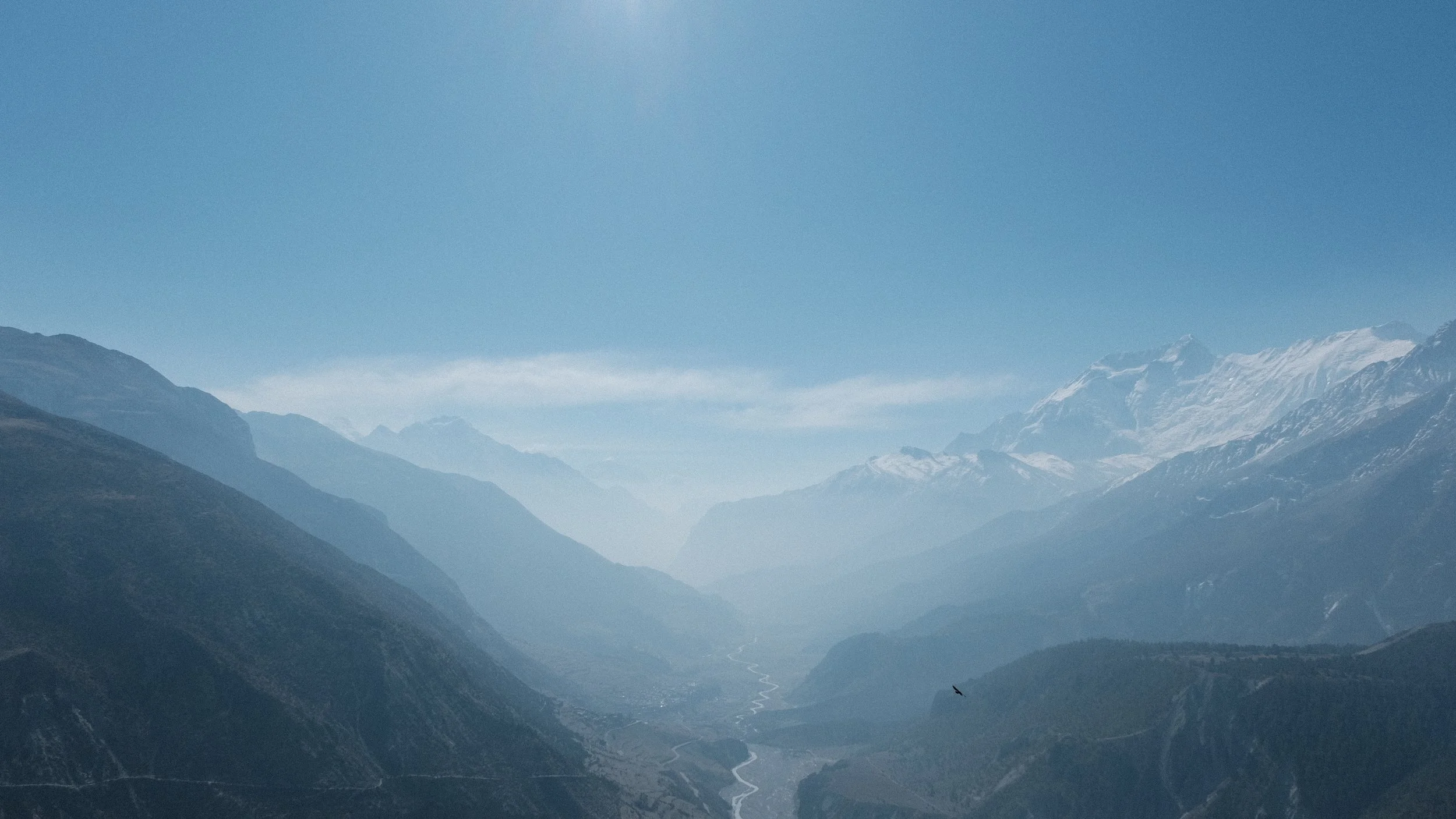 Foto de un valle rodeado de montañas en los Himalayas.