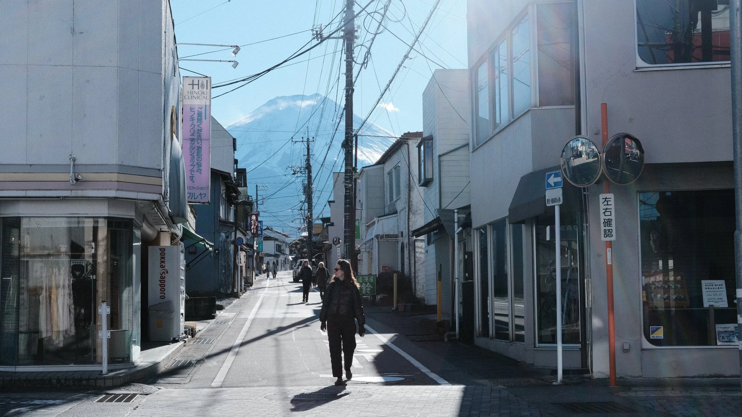 Persona en una calle japonesa con el Monte Fuji al fondo.