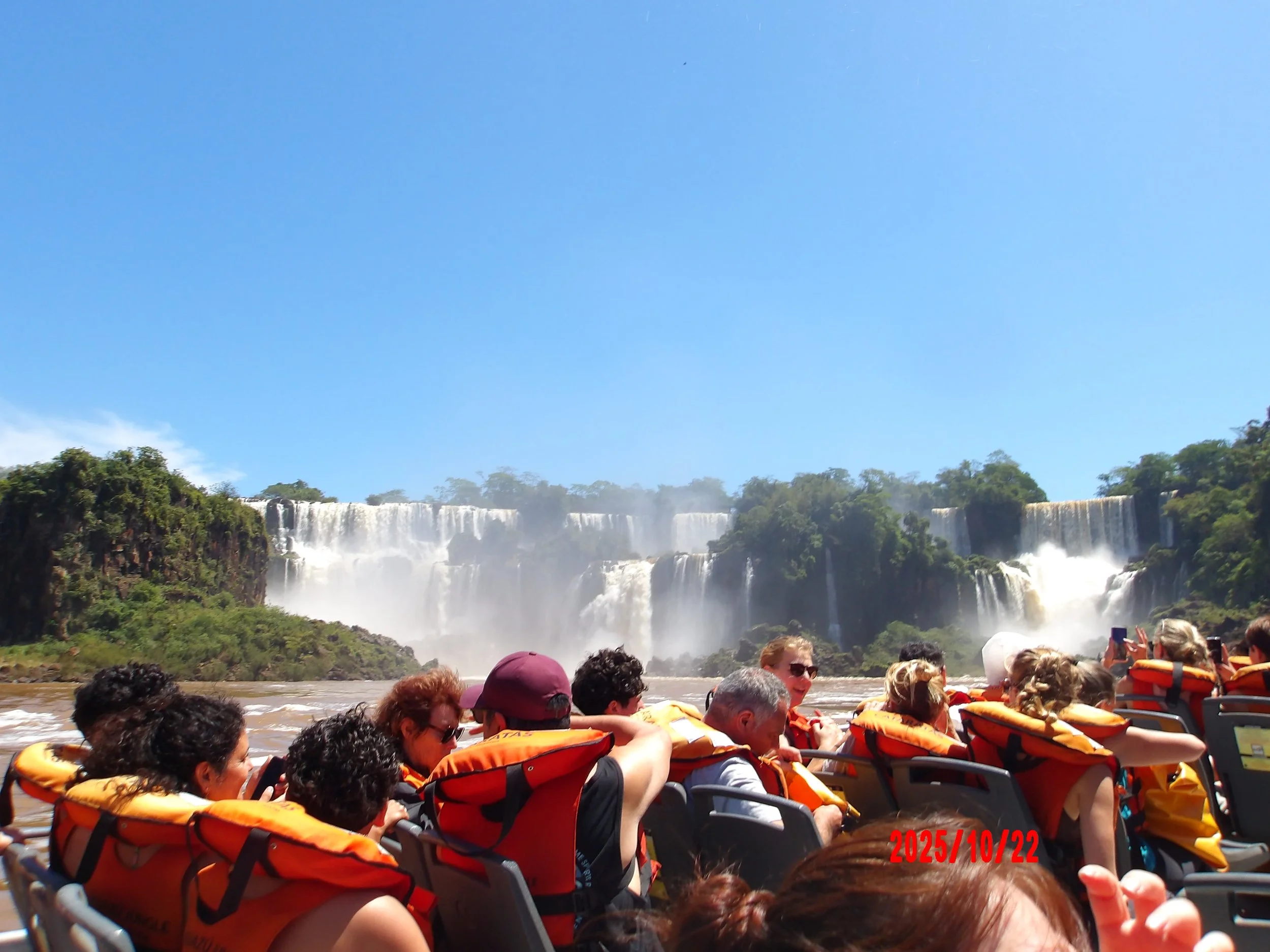 Bote lleno de personas con las Cataratas del Iguazú al fondo