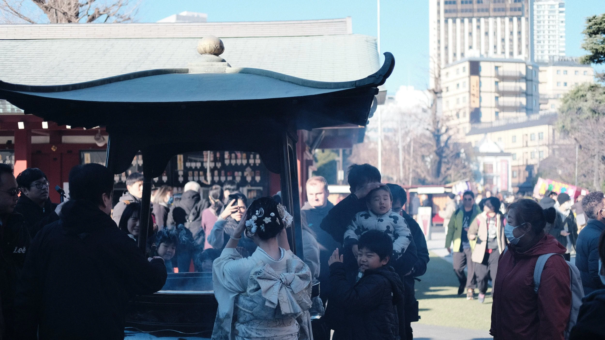 Personas purificándose con incienso en el templo Senso-ji, en Tokio.