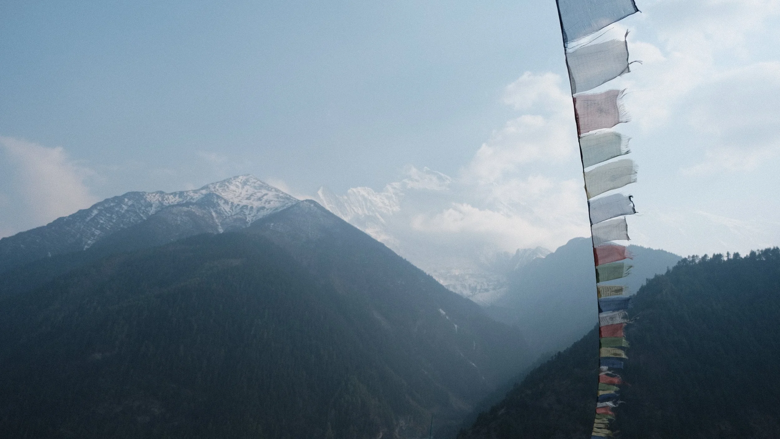 Banderas de oración con montañas detrás. En Nepal.