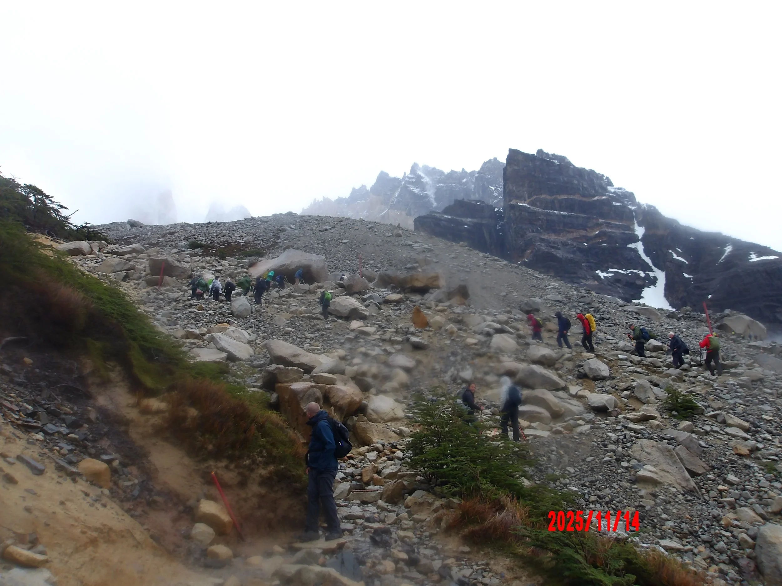 Personas subiendo por la montaña, con lluvia, en Torres del Paine