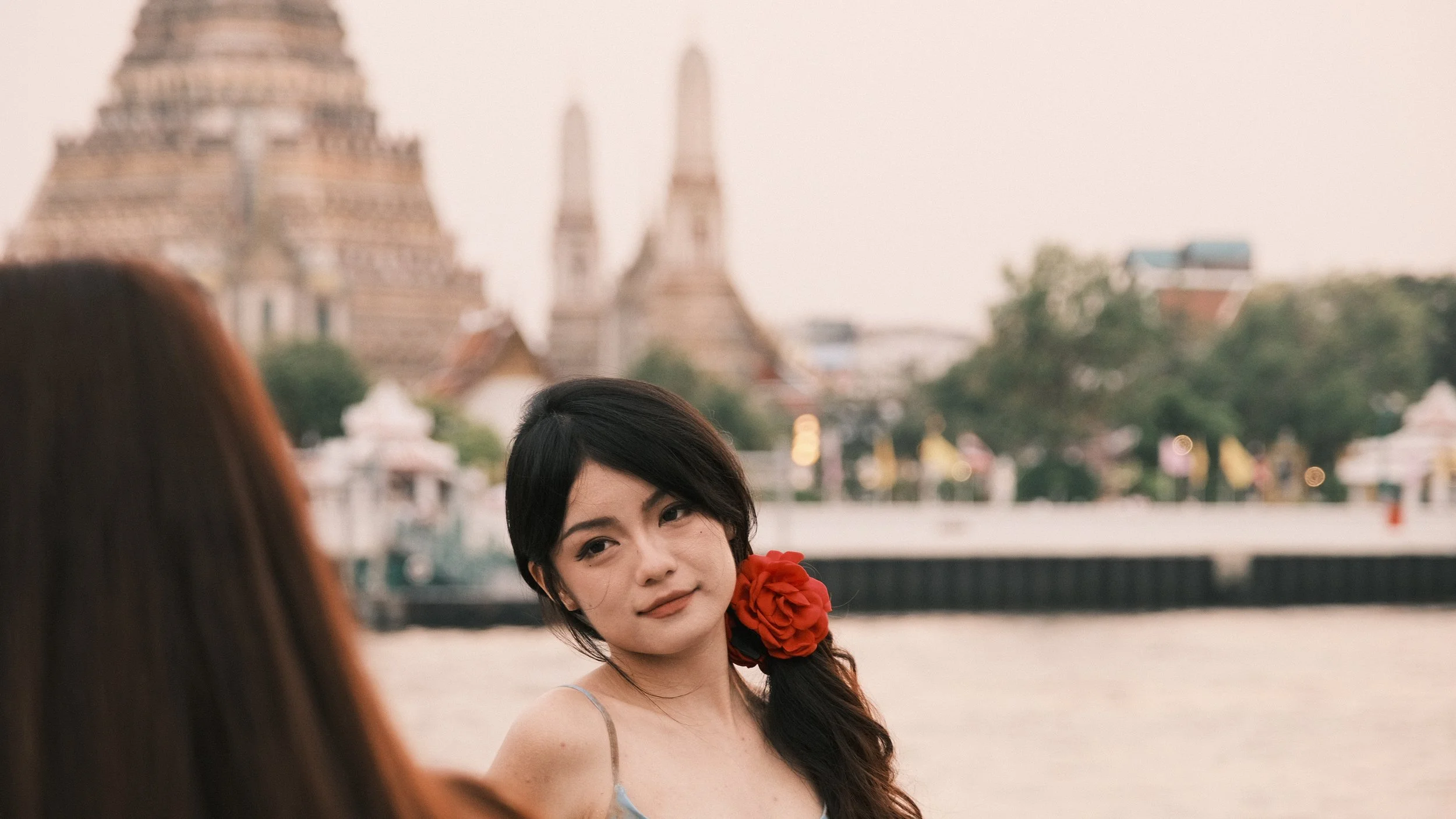 Mujer con el templo de Wat Arum al fondo en Bangkok