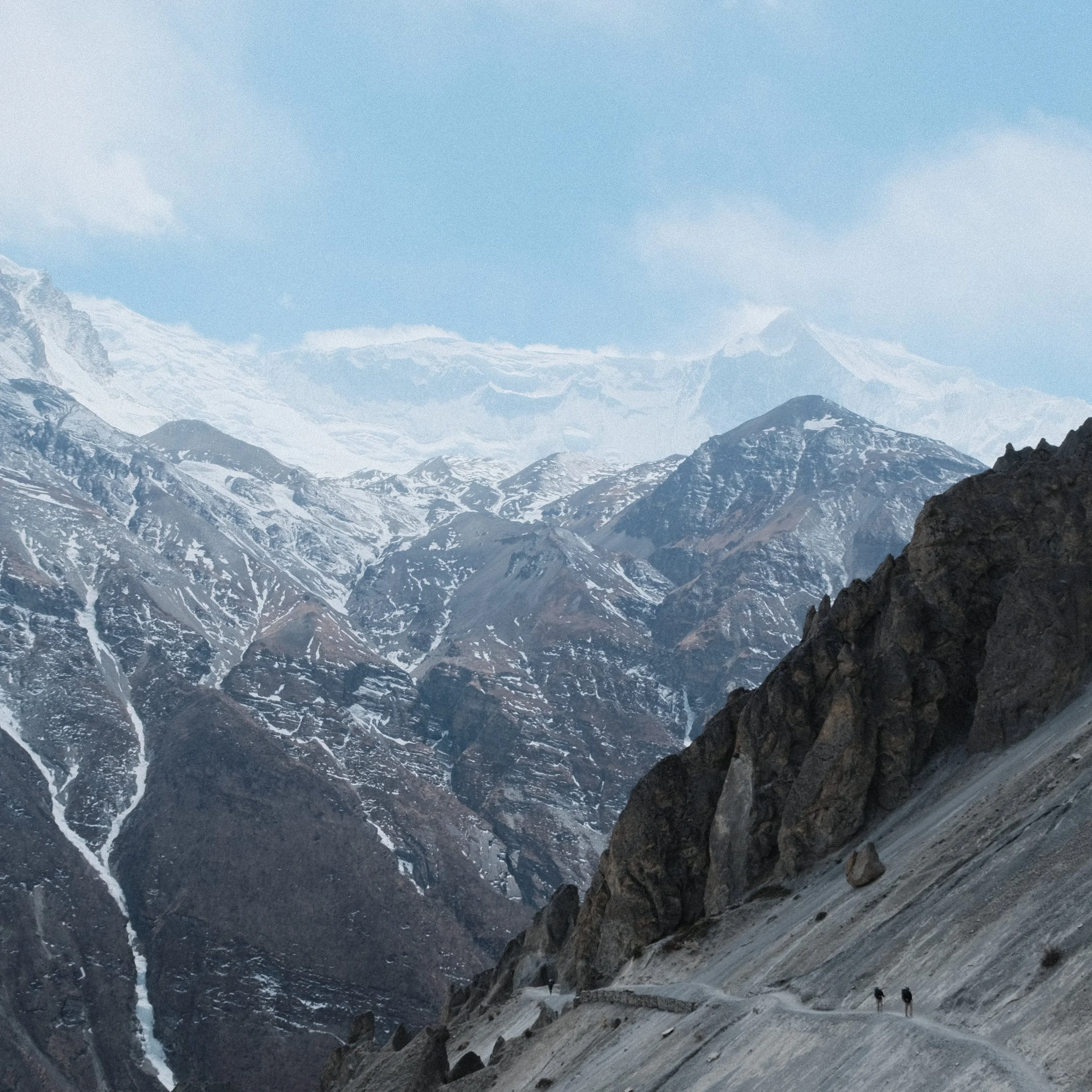 Montañas nevadas en Nepal con personas caminando.