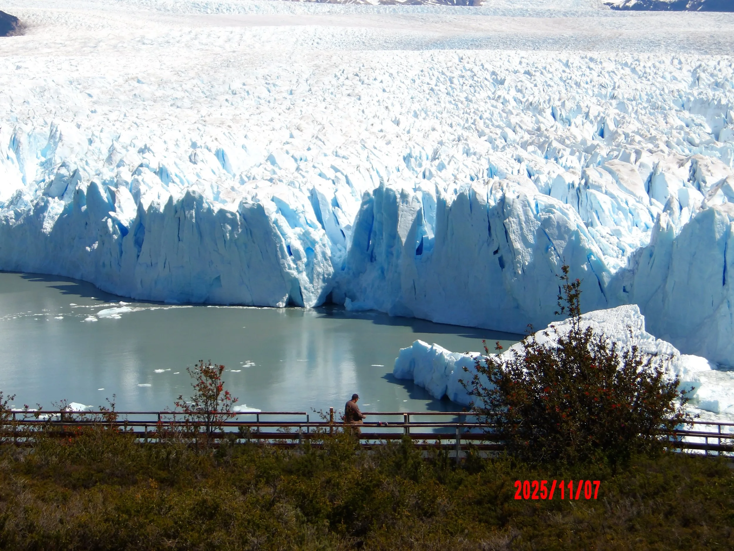 Persona caminando en una pasarela con el Glaciar Perito Moreno al fondo